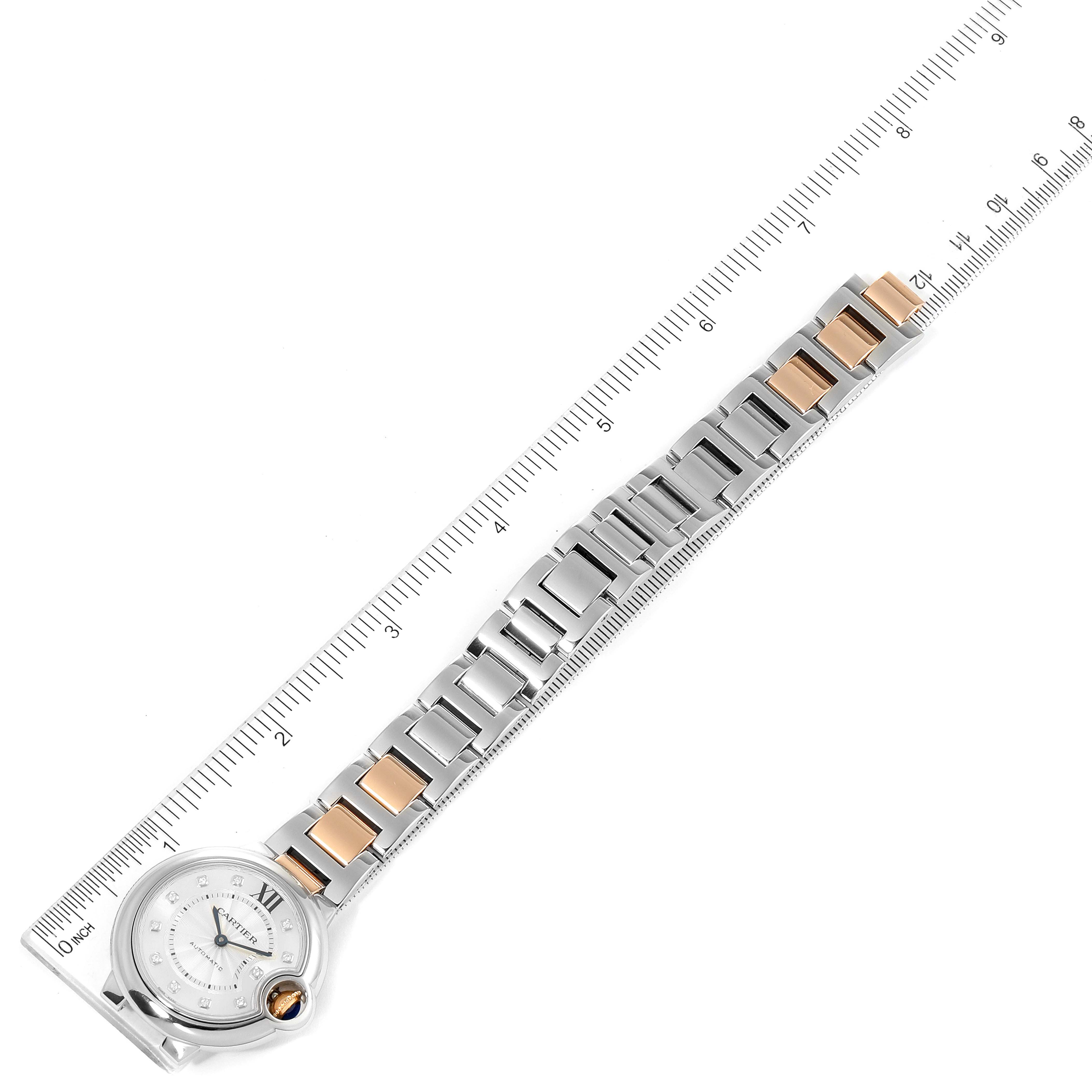 The image shows the Ballon Bleu de Cartier watch laid flat next to a ruler, displaying its full bracelet and face.