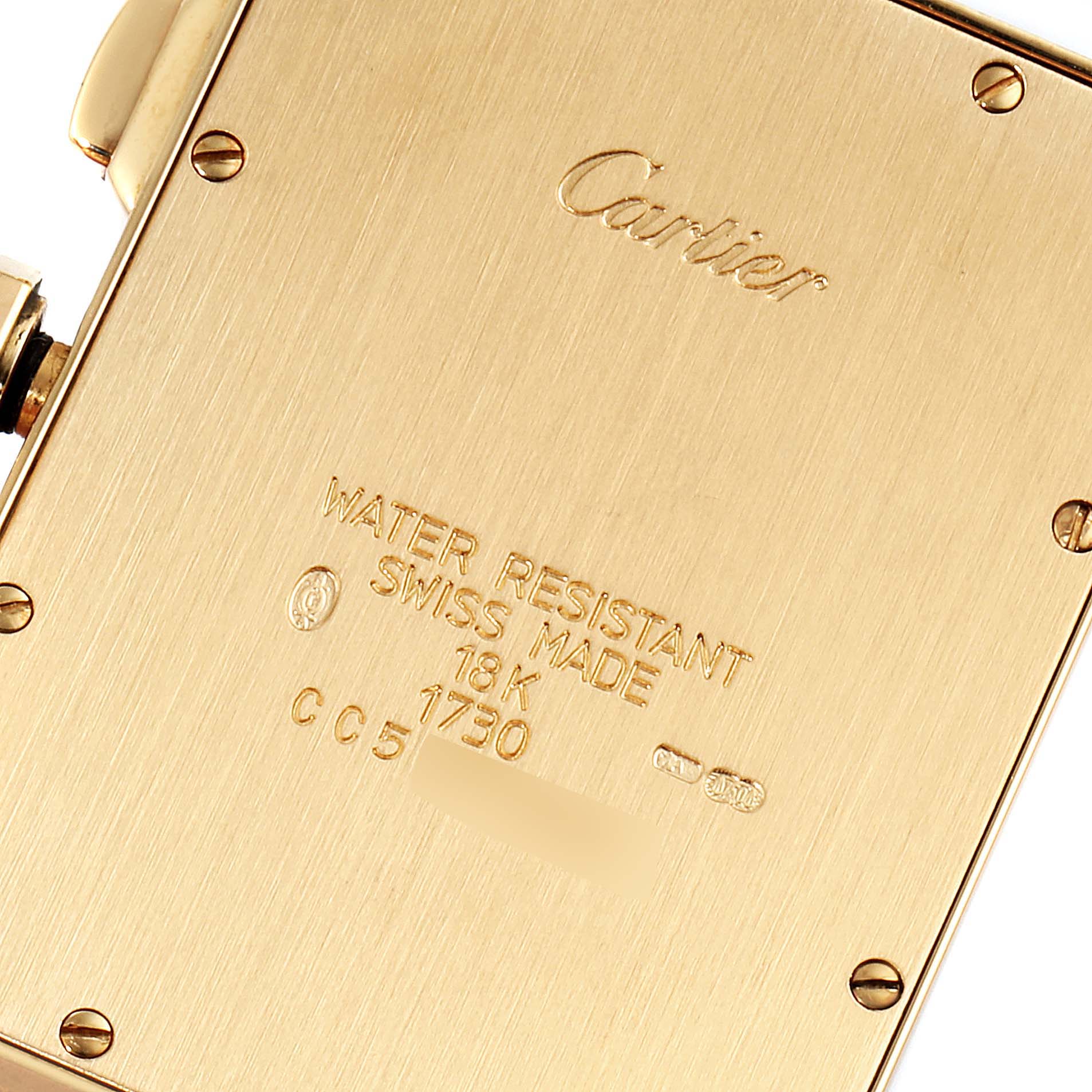 This image shows the back case of the Cartier Tank Americaine W2601156 Men's Yellow Gold Silver Dial W2601156 Men's Yellow Gold Silver Dial watch, highlighting the engravings and screws.