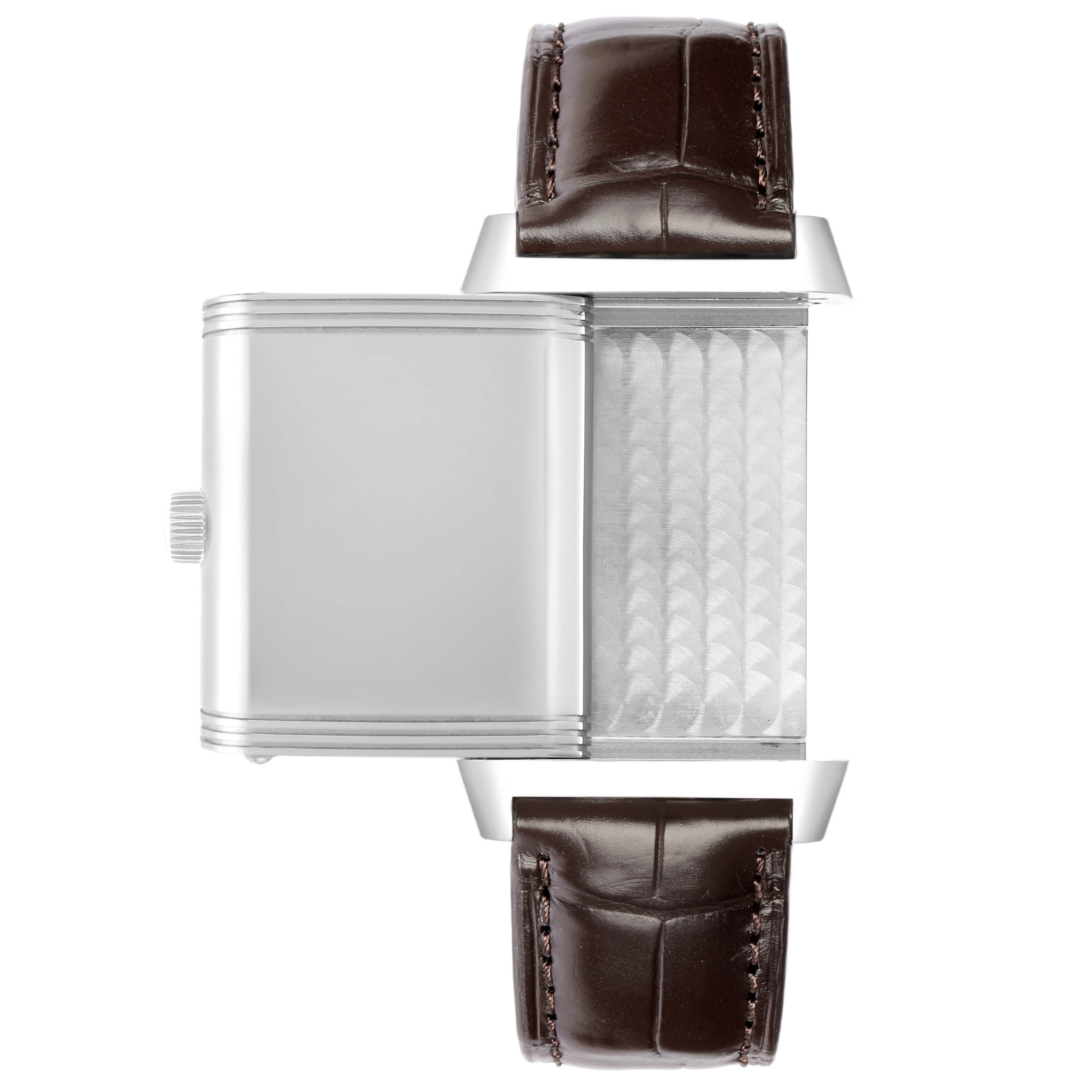 The image shows the side view of a Jaeger LeCoultre Reverso Q3038420 Men
s Stainless Steel Silver Dial watch with its case partially opened, highlighting the articulation and textured back.