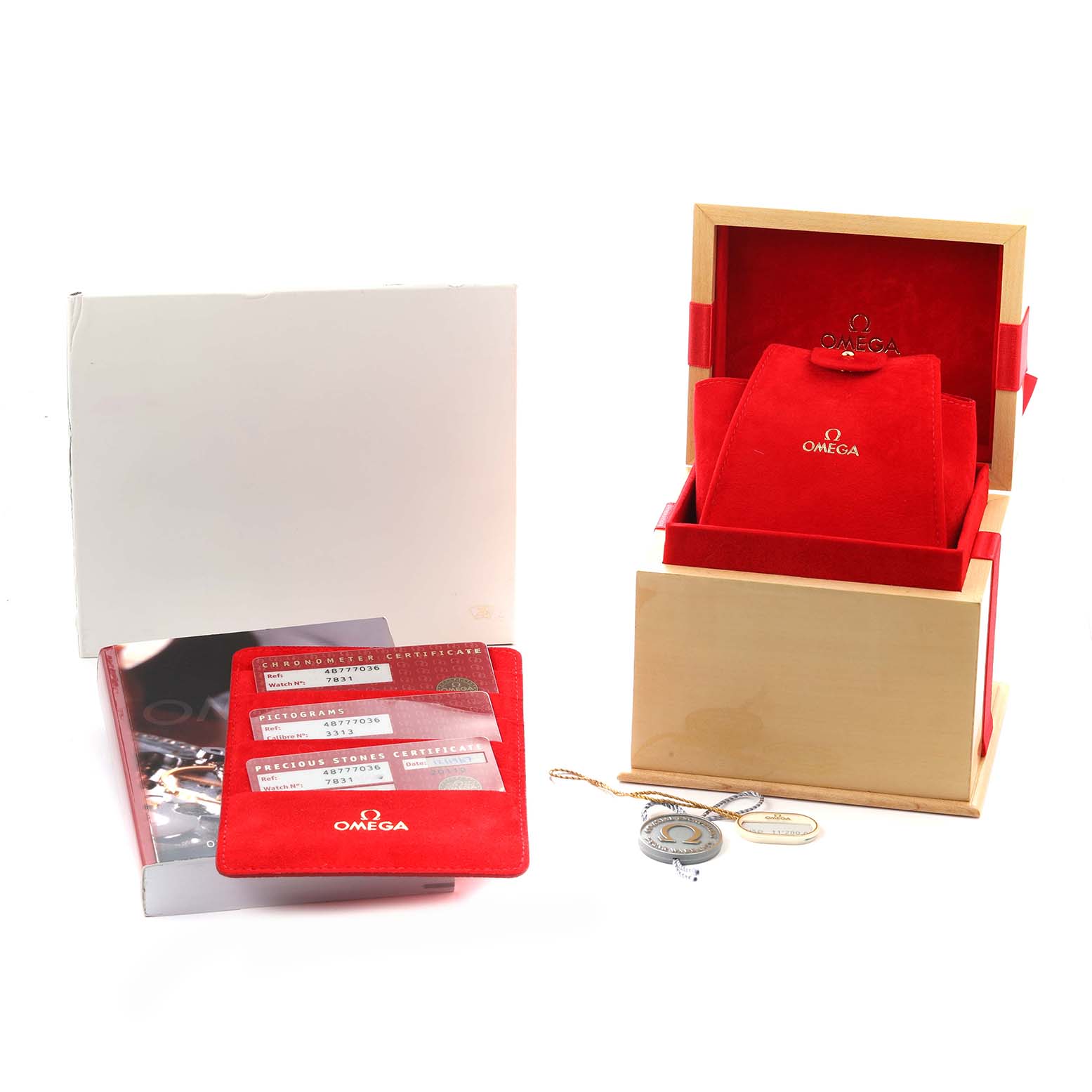 The image shows Omega De Ville 4877.70.36 Men
s Stainless Steel Mother of Pearl Dial accessories: red presentation box, certificates, and a manual.