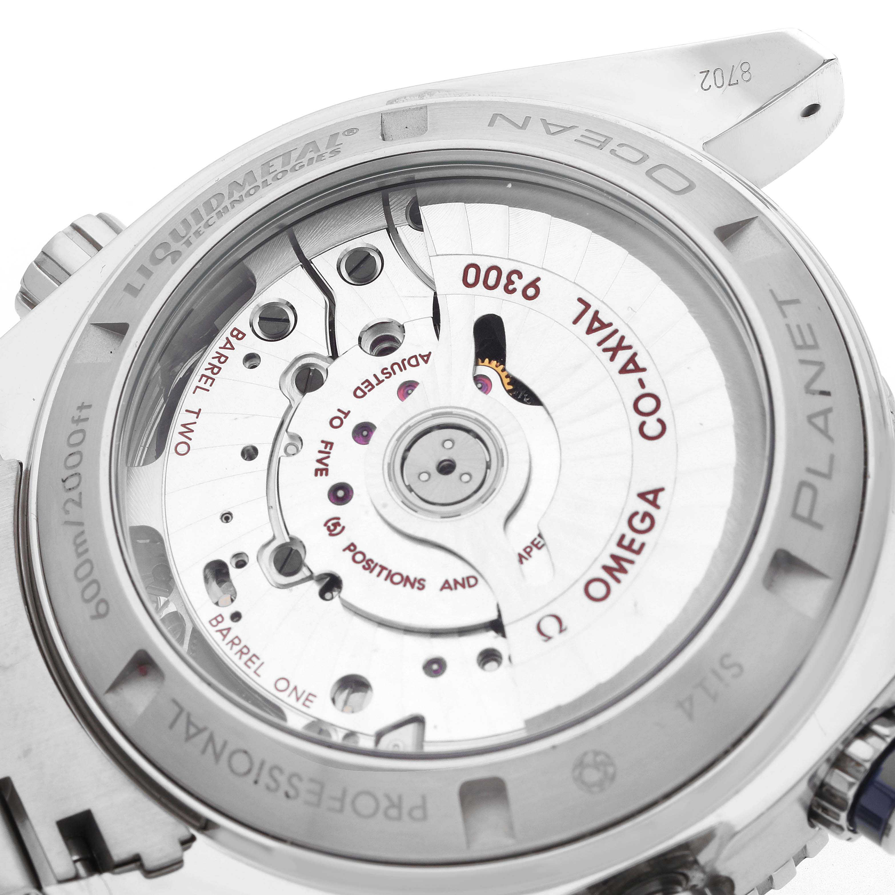 The image shows the underside of the Omega Planet Ocean 232.90.46.51.03.001 Men
s Titanium Blue Dial watch, highlighting the movement and intricate co-axial mechanism.