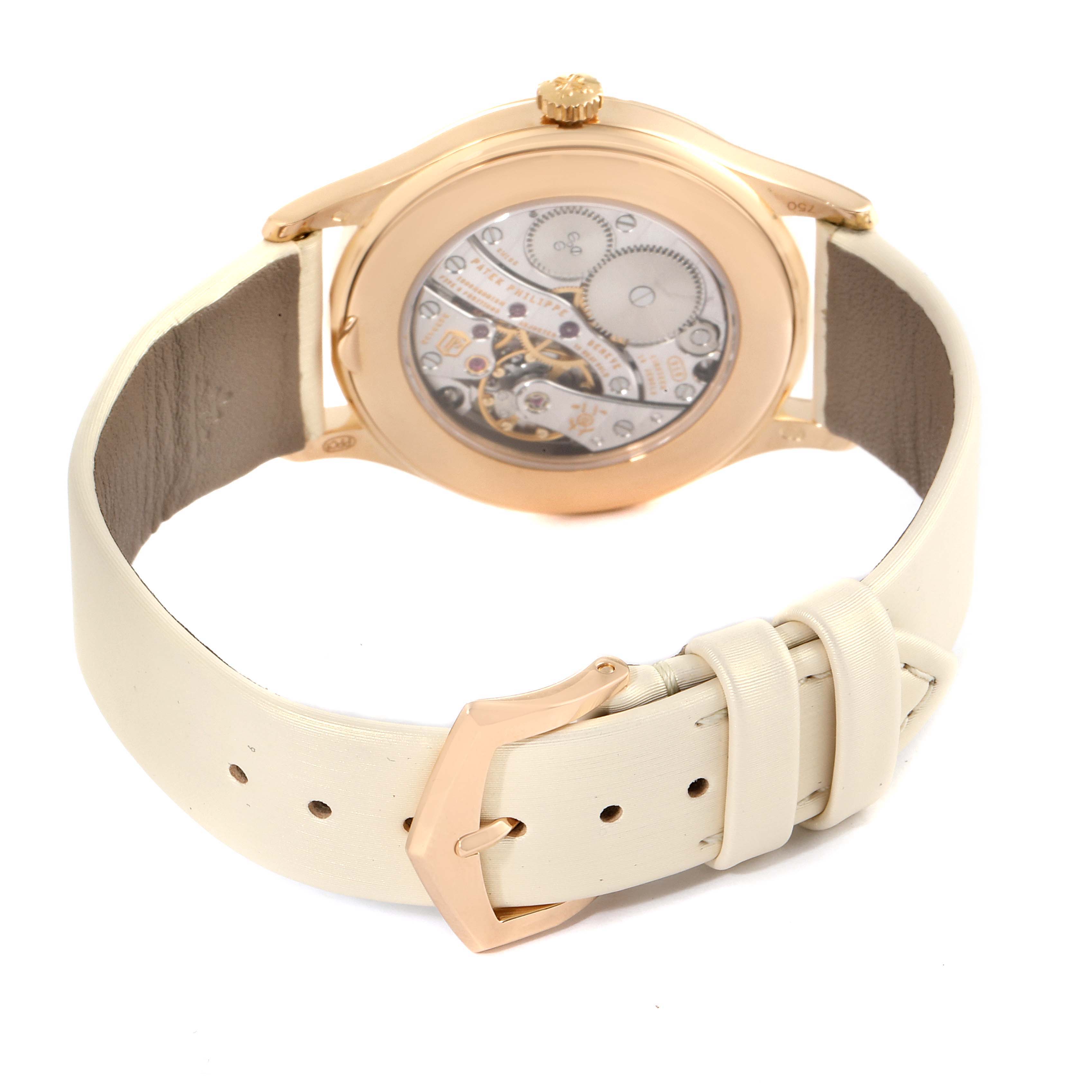 The image shows the back view of a Patek Philippe Calatrava 4897R-010 Women
s Rose Gold Beige Dial 4897R-010 Women
s Rose Gold Beige Dial watch, highlighting its movement and cream-colored strap.