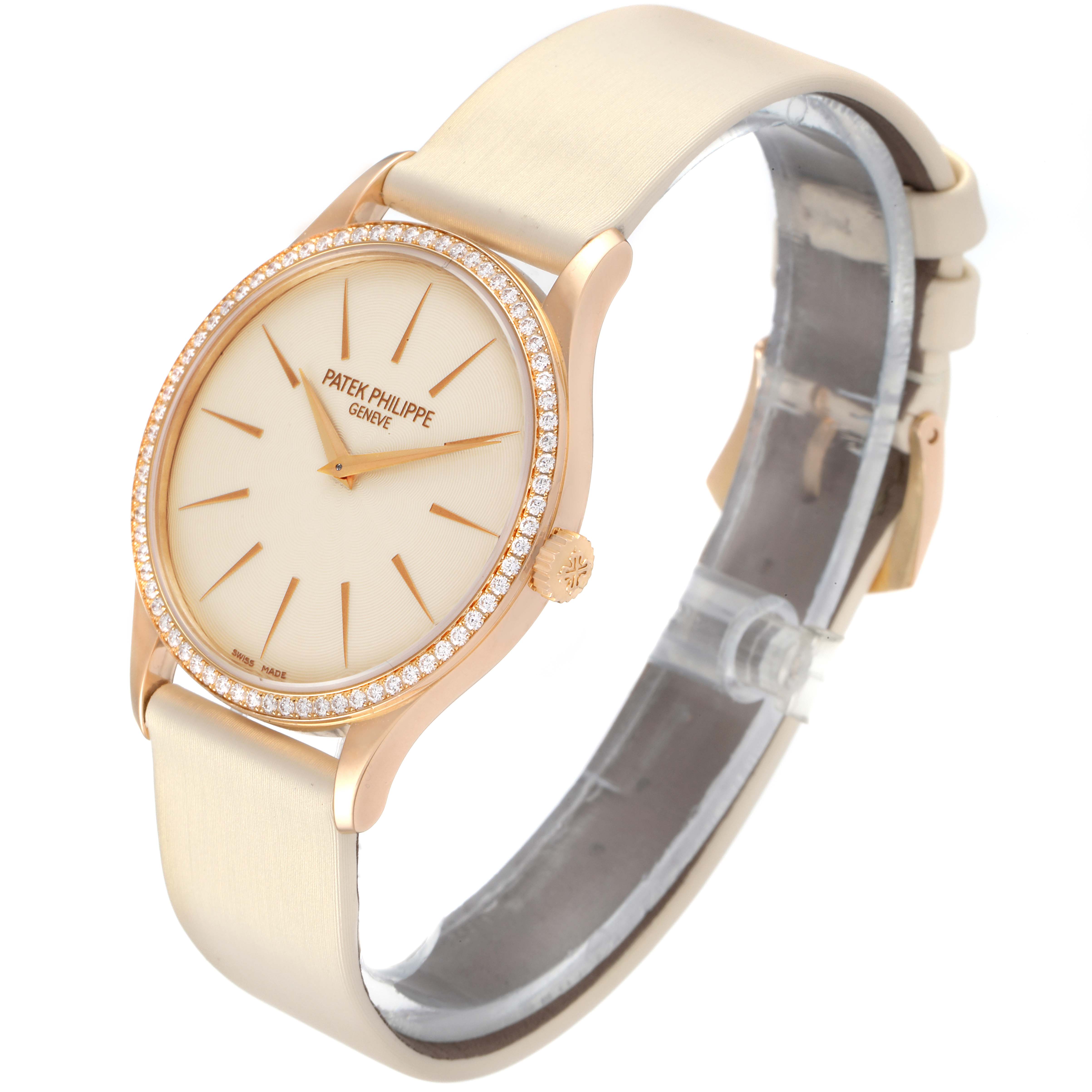 The Patek Philippe Calatrava 4897R-010 Women
s Rose Gold Beige Dial 4897R-010 Women
s Rose Gold Beige Dial watch is shown at an angled side view, displaying the watch face, bezel with diamonds, and beige strap.