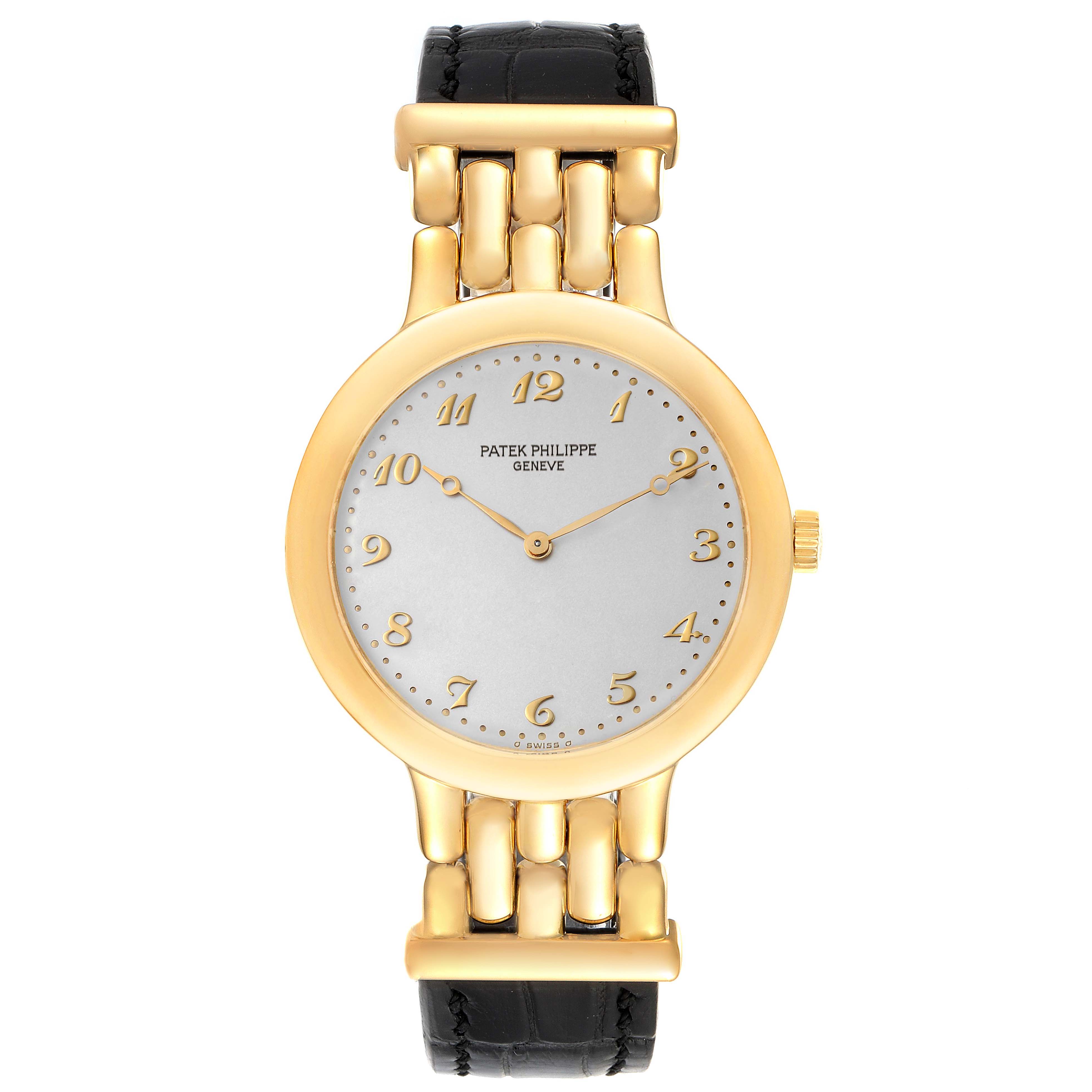 The image shows a front view of a Patek Philippe Calatrava 3915J Men's Yellow Gold Silver Dial 3915J Men's Yellow Gold Silver Dial watch with a gold case and black leather strap.