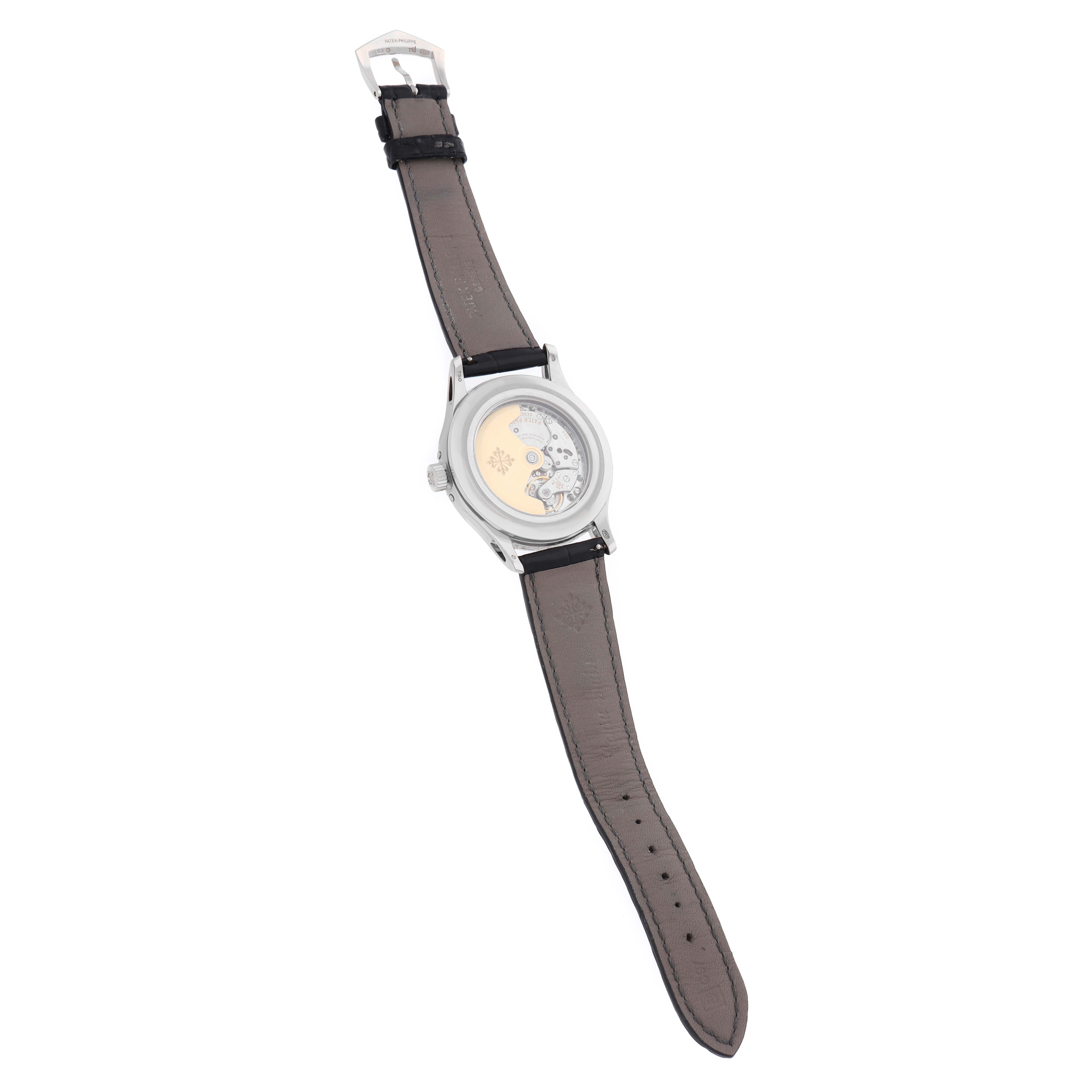 The Patek Philippe Complications 5205 Men
s White Gold Black Dial watch is shown from the back, displaying its open case back and leather strap.