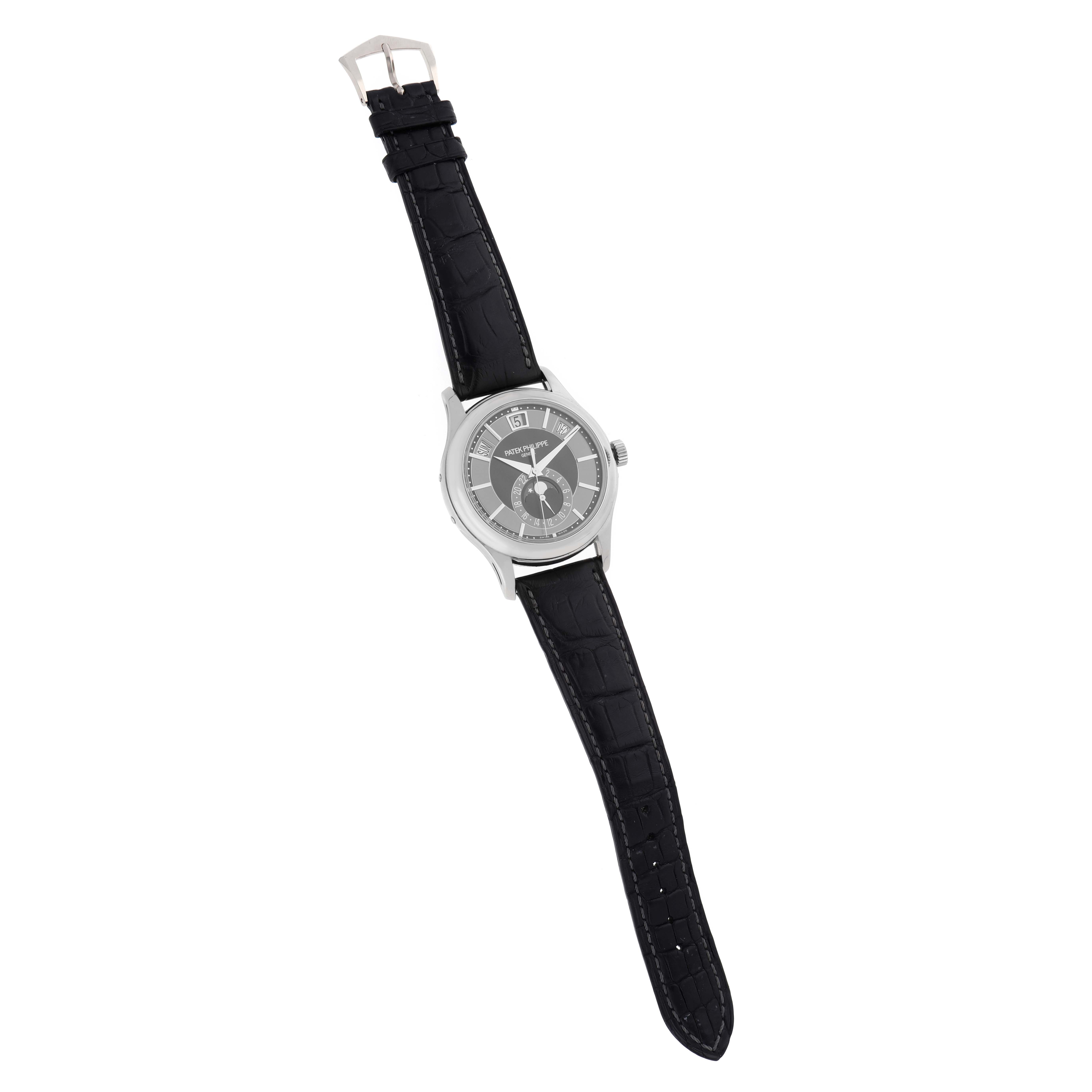 The Patek Philippe Complications 5205 Men
s White Gold Black Dial watch is shown from a top view, highlighting the dial, case, and leather strap.