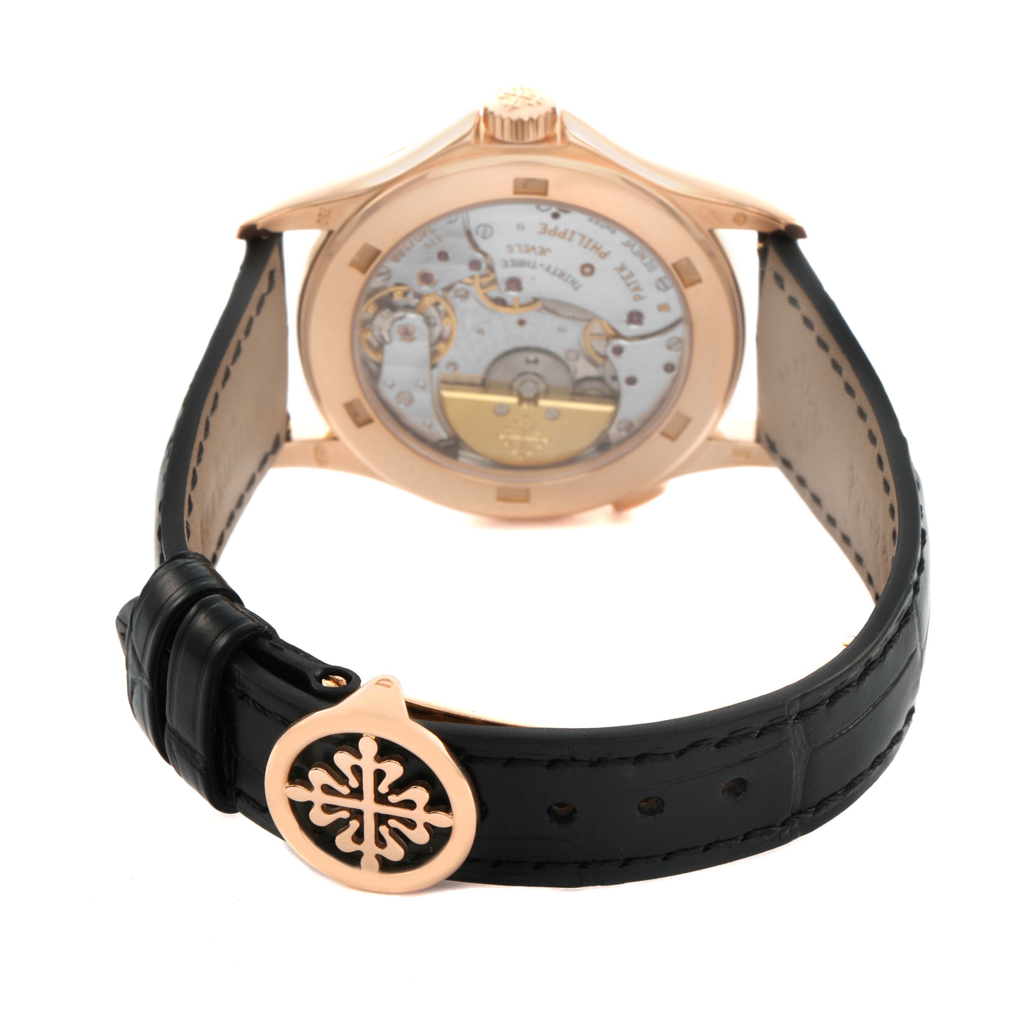 The image shows the back view of the Patek Philippe Complications 5110R-001 Men's Rose Gold Silver Dial watch, highlighting the movement mechanism and black strap.