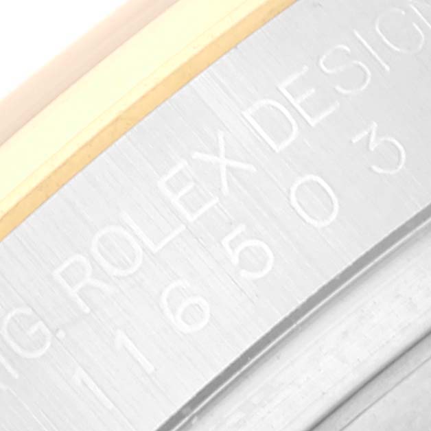 This image shows an angled close-up of the case side with engraved text from a Rolex Daytona 116503 Men
s Steel and Gold (two tone) Black Dial 116503 Men
s Steel and Gold (two tone) Black Dial watch.