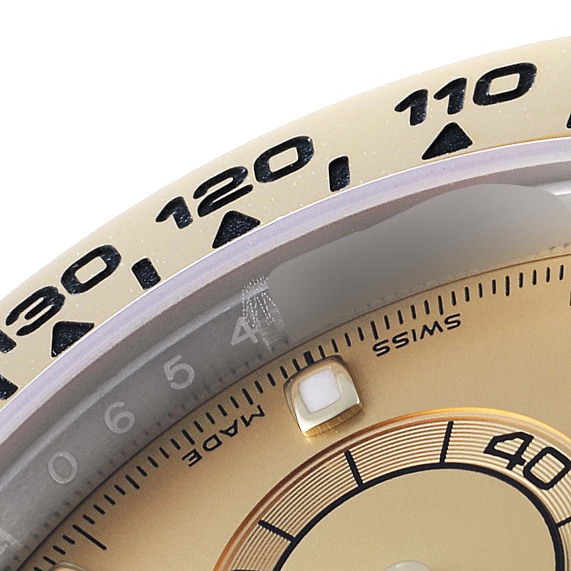 A close-up angle of the Rolex Daytona 116503 Men
s Steel and Gold (two tone) Champagne Dial 116503 Men
s Steel and Gold (two tone) Champagne Dial watch shows the bezel with tachymeter scale, part of the dial, and a luminescent hour marker.