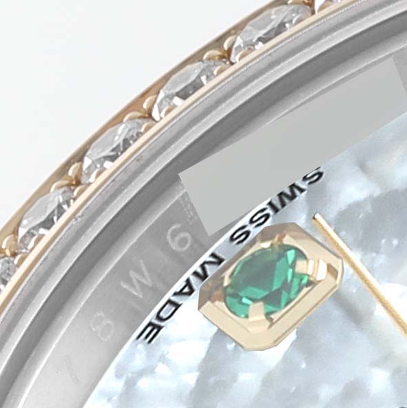 The close-up image shows the bezel and part of the dial of a Rolex Datejust 179383 Women's Steel and Gold (two tone) Mother of Pearl Dial 179383 Women's Steel and Gold (two tone) Mother of Pearl Dial watch with an emerald marker and diamond-studded edge.
