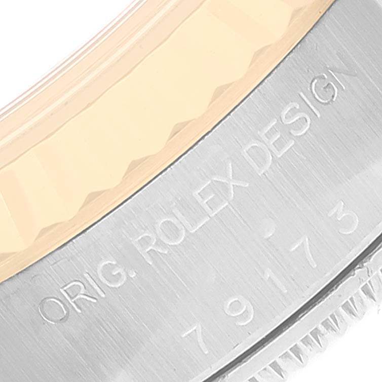 The image shows a close-up of the side of the bezel and caseback rim with engraved text for the Rolex Datejust 79173 Women's Steel and Gold (two tone) Beige Dial 79173 Women's Steel and Gold (two tone) Beige Dial model.