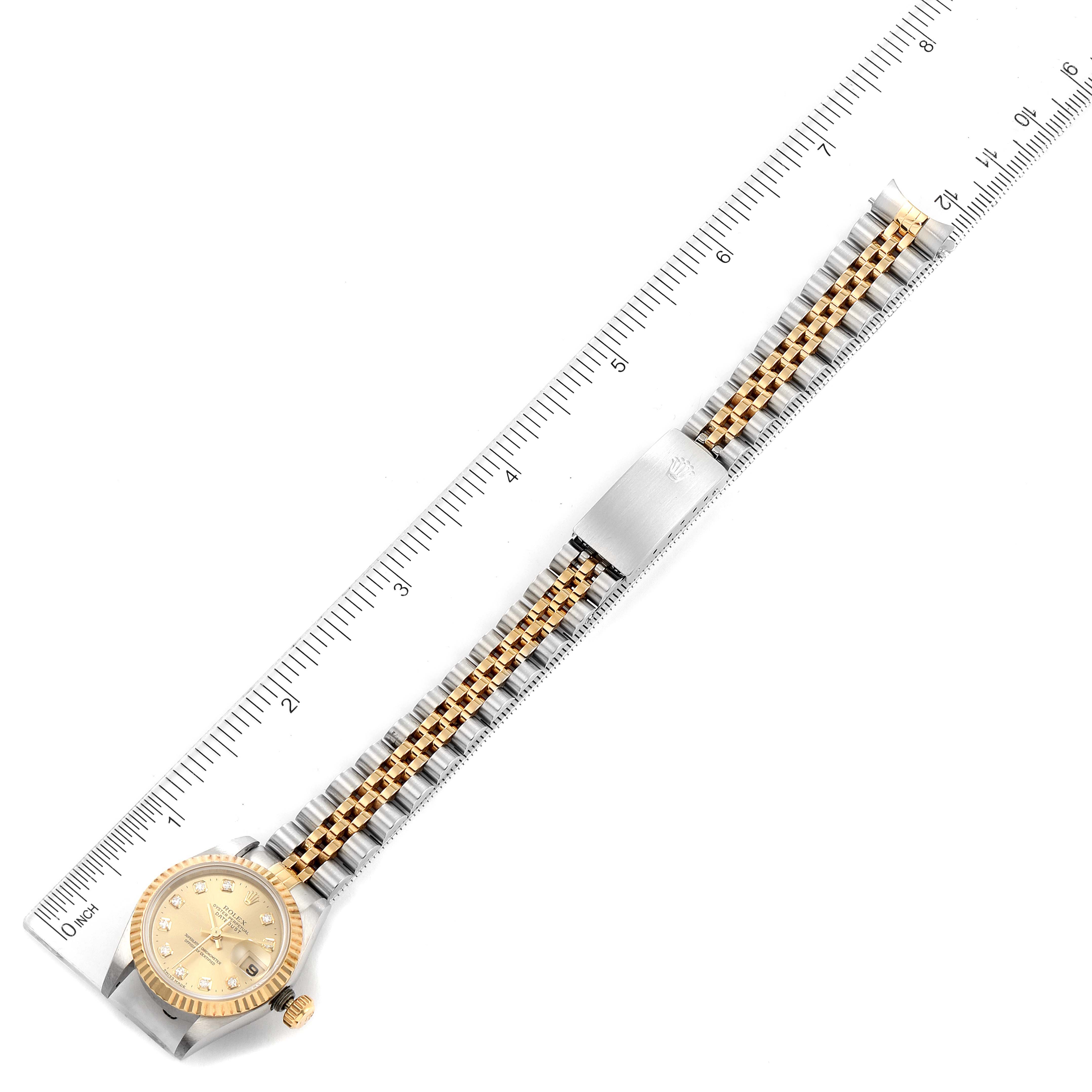 This image shows an overhead view of a Rolex Datejust 69173 Women's Steel and Gold (two tone) Champagne Dial 69173 Women's Steel and Gold (two tone) Champagne Dial watch, highlighting its face, bezel, and part of its bracelet alongside a ruler.