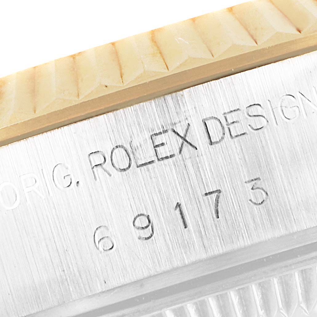The image shows a close-up of the Rolex Datejust 69173 Women's Steel and Gold (two tone) Champagne Dial 69173 Women's Steel and Gold (two tone) Champagne Dial model's case side with engraved serial and model numbers.