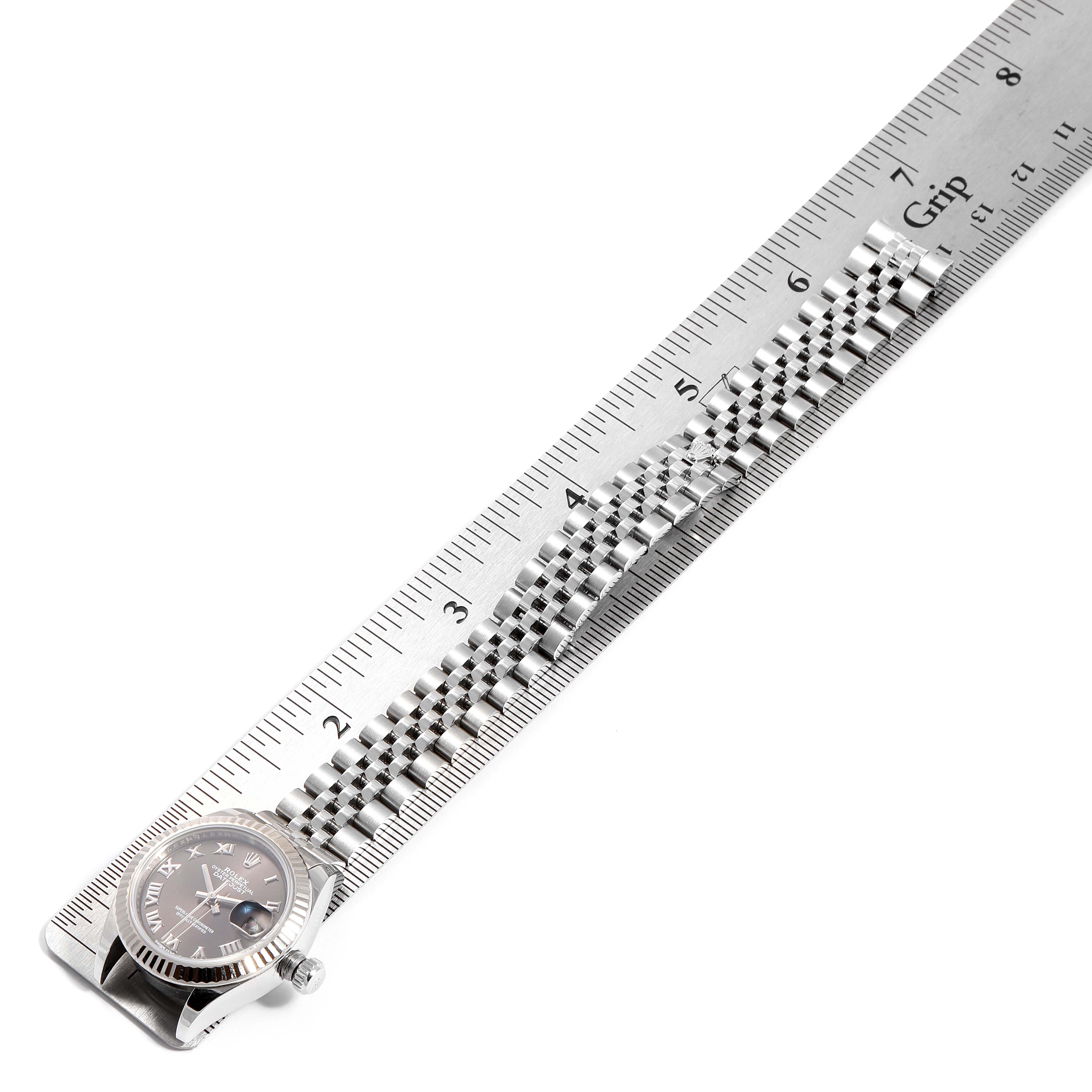 The image shows a Rolex Datejust 279174 Women's Stainless Steel Brown Dial 279174 Women's Stainless Steel Brown Dial watch placed next to a ruler, displaying its face and metal bracelet from a top-down angle.