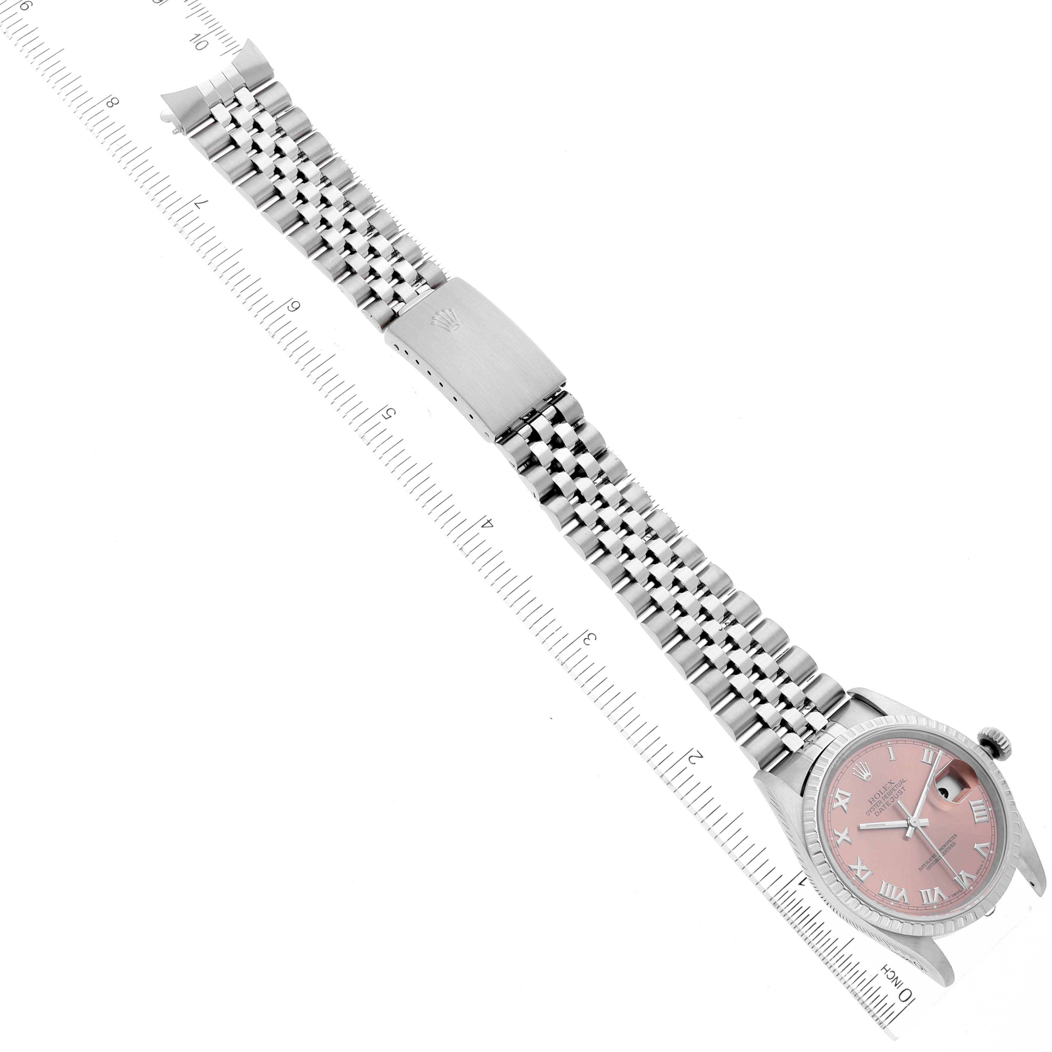 The image shows a Rolex Datejust 16220 Men's Stainless Steel Pink Dial 16220 Men's Stainless Steel Pink Dial watch from an overhead angle, displaying the face, bracelet, and clasp with a measurement ruler.