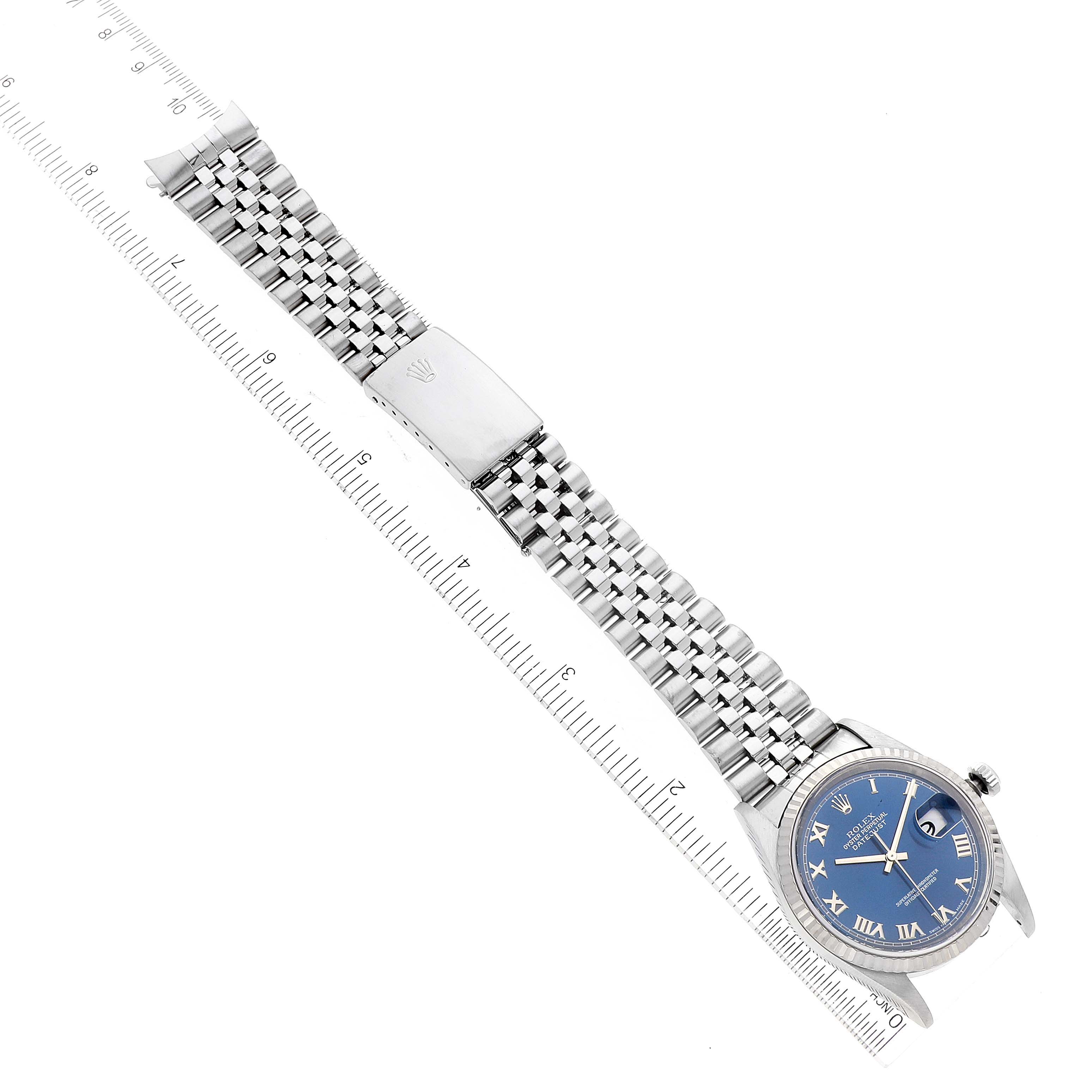 The image shows a Rolex Datejust 16234 Men's Stainless Steel Blue Dial 16234 Men's Stainless Steel Blue Dial watch laid flat with its strap extended and a ruler beside it for measurement.