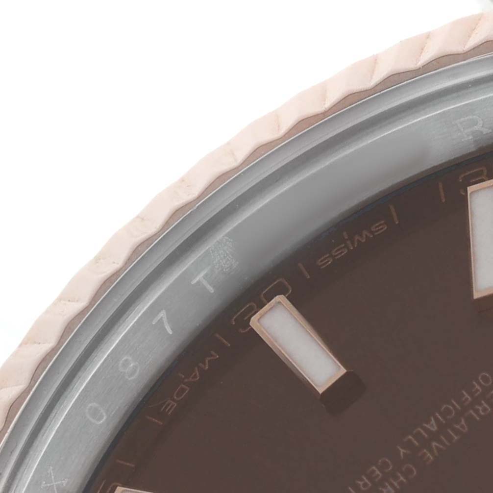 The image shows a close-up of the bezel and part of the dial of a Rolex Datejust 41 126331 Men's Steel and Gold (two tone) Brown Dial, highlighting the fluted texture and hour markers.