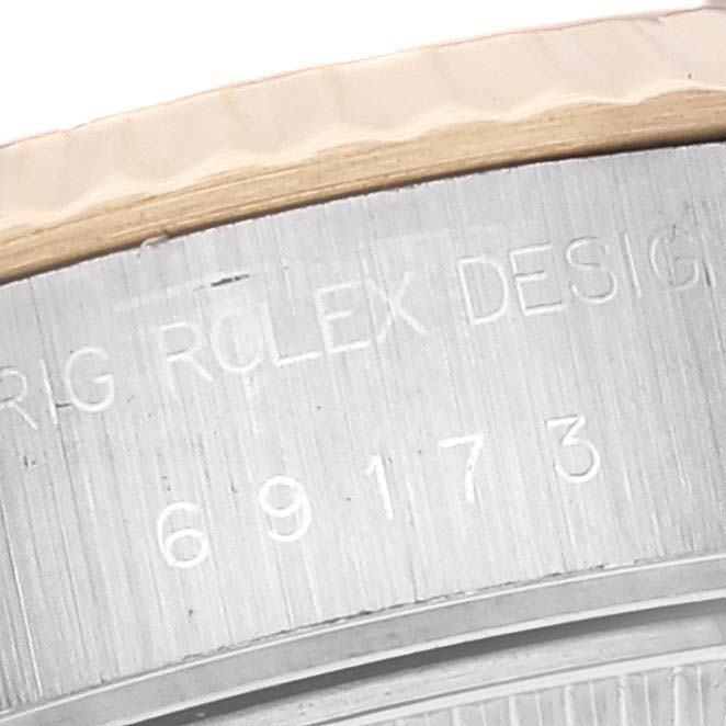 This close-up image shows the engraved serial number on the side of a Rolex Datejust 69173 Women's Steel and Gold (two tone) Black Dial 69173 Women's Steel and Gold (two tone) Black Dial watch case.