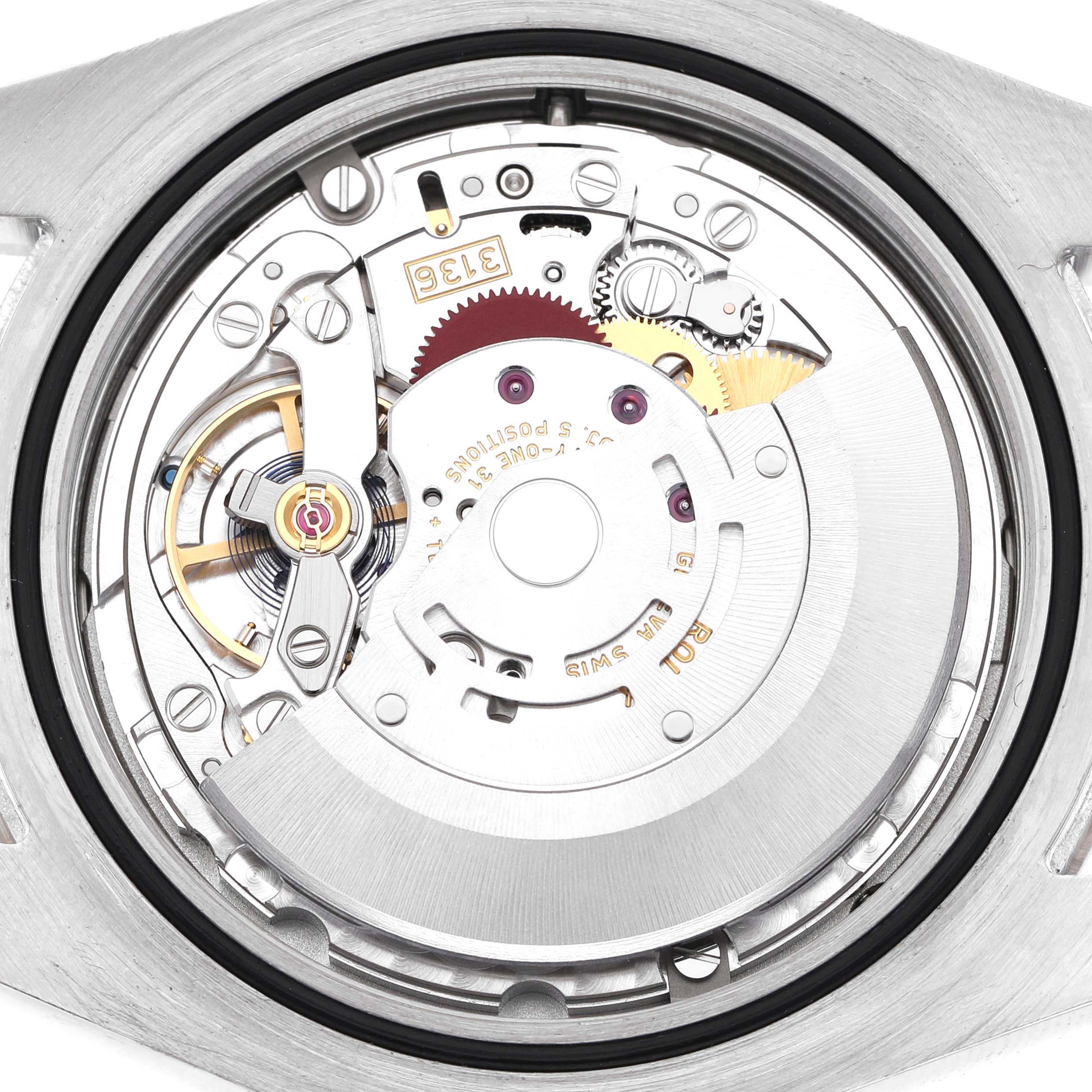 The image shows the movement of a Rolex Datejust 116334 Men's Stainless Steel Blue Dial watch from a back angle, displaying gears and mechanical components.