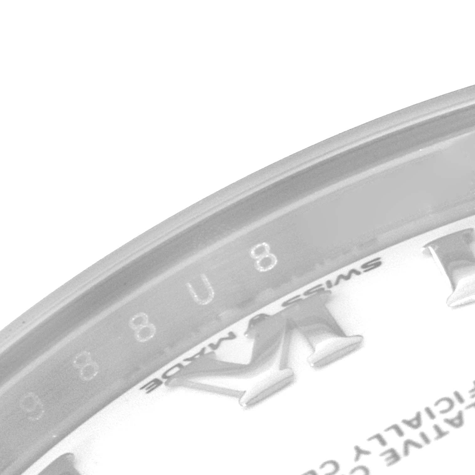 The image shows an angled close-up of the dial and bezel of a Mid-Size Rolex watch, featuring markers and "Swiss Made" text.