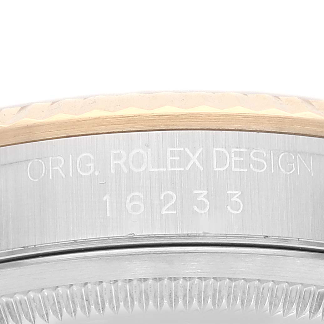 The image shows an angled close-up of the engraved case side and fluted bezel of a Rolex Datejust 16233 Men's Steel and Gold (two tone) White Dial 16233 Men's Steel and Gold (two tone) White Dial watch.