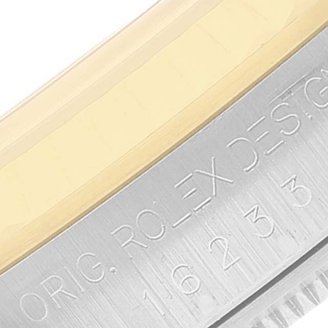 Close-up of the bezel and the engraved case side of a Rolex Datejust 16233 Men's Steel and Gold (two tone) Blue Dial 16233 Men's Steel and Gold (two tone) Blue Dial watch.