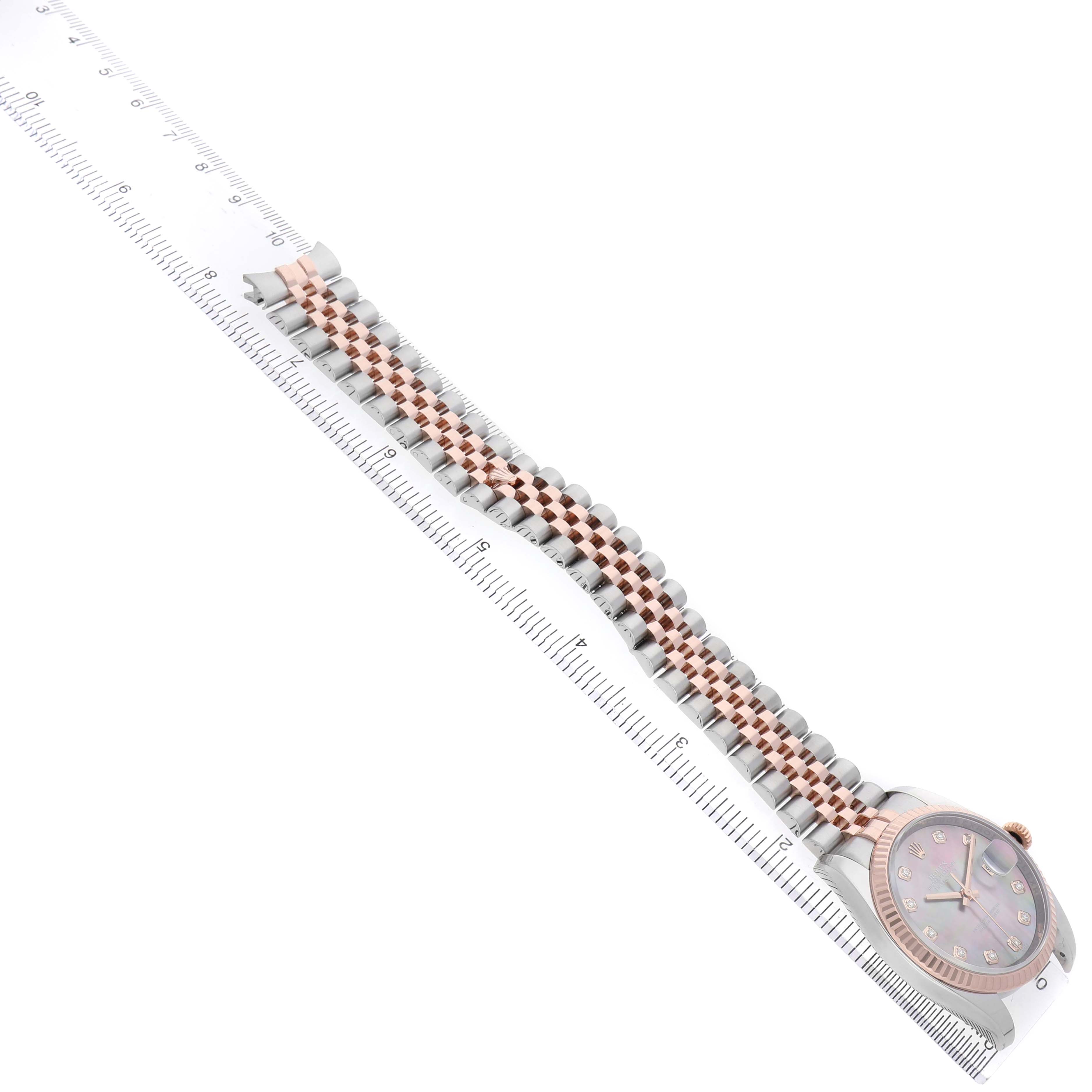 The Rolex Datejust 116231 Men's Steel and Gold (two tone) Mother of Pearl Dial is shown at a side angle, displaying its dial and two-tone bracelet alongside a ruler for scale.