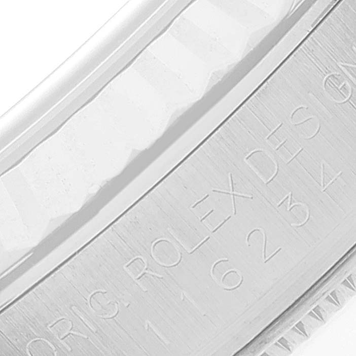 This close-up image shows the engraved edge of the bezel of a Rolex Datejust 116234 Men's Stainless Steel Silver Dial 116234 Men's Stainless Steel Silver Dial watch.