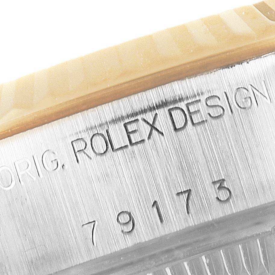 This image shows a close-up of the serial number and "ROLEX DESIGN" lettering on the casing of a Rolex Datejust 79173 Women's Steel and Gold (two tone) Blue Dial 79173 Women's Steel and Gold (two tone) Blue Dial watch.