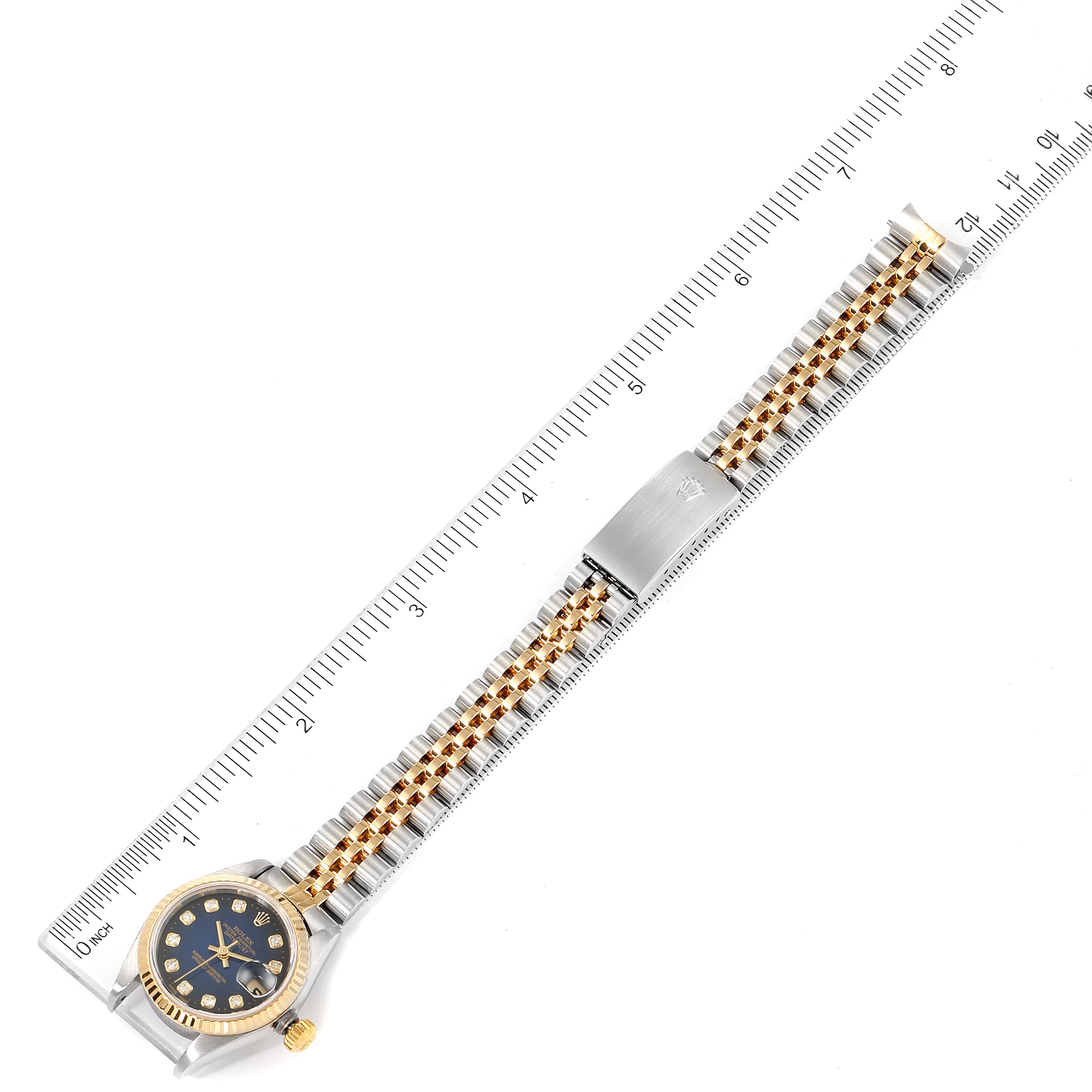 The image shows a top-down view of a Rolex Datejust 79173 Women's Steel and Gold (two tone) Blue Dial 79173 Women's Steel and Gold (two tone) Blue Dial watch with a ruler for scale, highlighting the face and entire band.