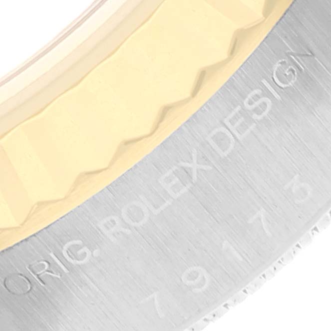 The image shows a close-up of the bezel and engraved case of a Rolex Datejust 79173 Women's Steel and Gold (two tone) Champagne Dial 79173 Women's Steel and Gold (two tone) Champagne Dial watch.