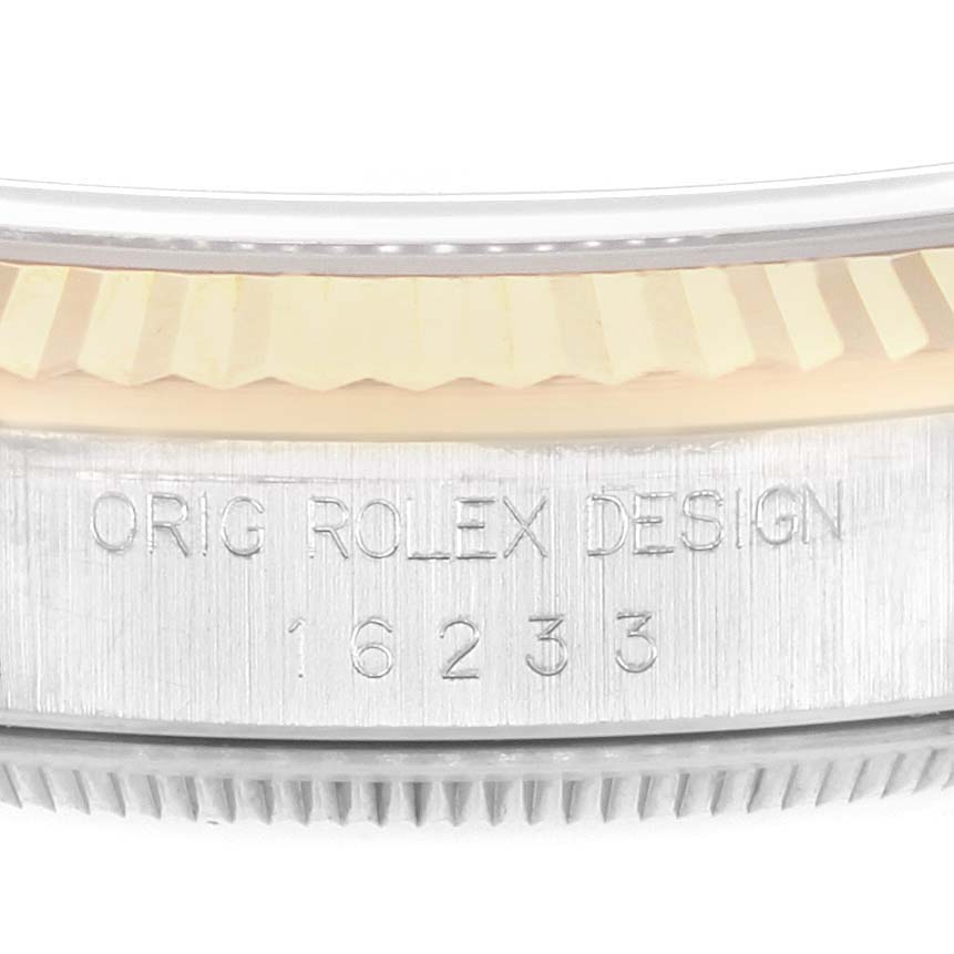 The image shows a close-up of the engraved side of the case and part of the fluted bezel on a Rolex Datejust 16233 Men's Steel and Gold (two tone) Champagne Dial 16233 Men's Steel and Gold (two tone) Champagne Dial.