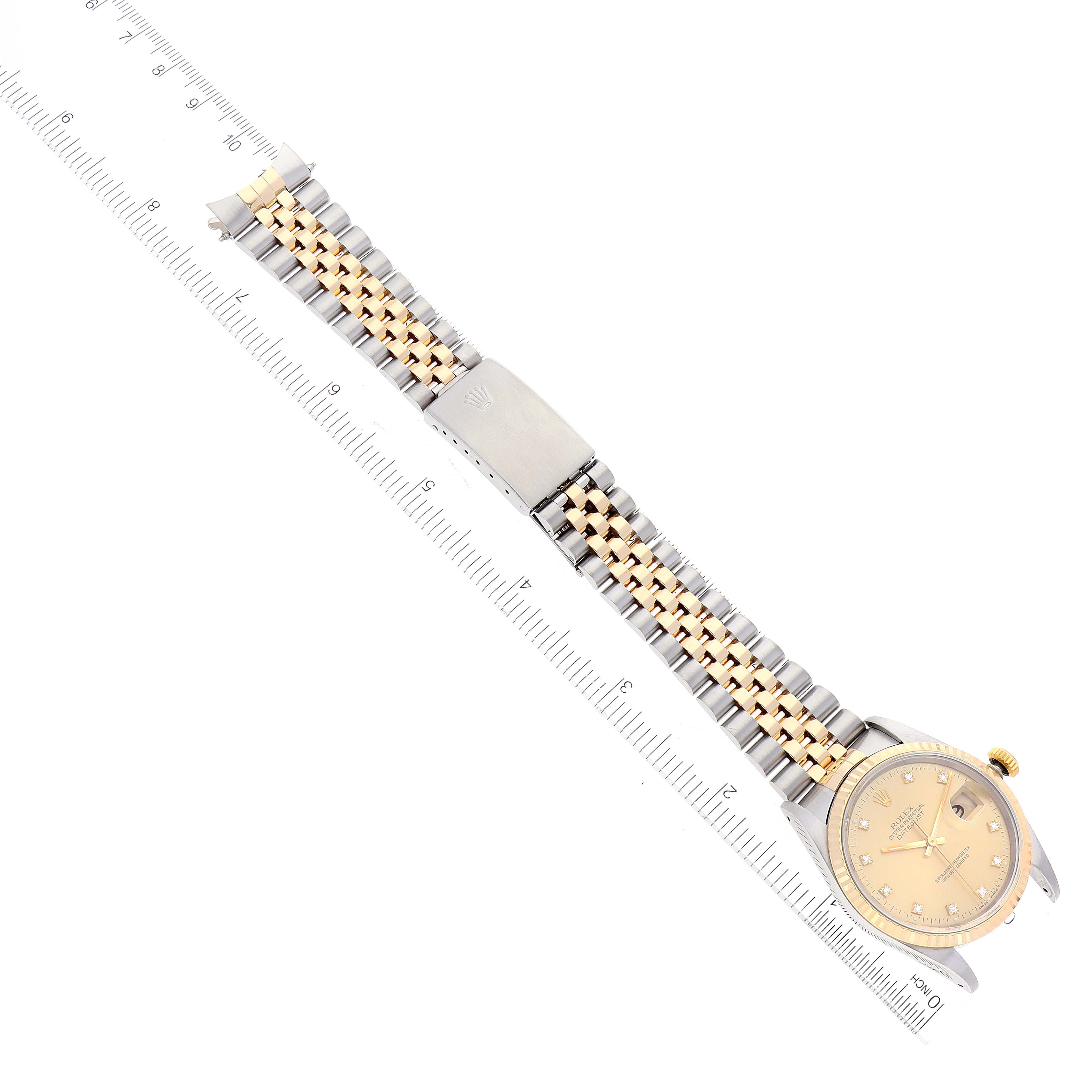 The image shows a Rolex Datejust 16233 Men's Steel and Gold (two tone) Champagne Dial 16233 Men's Steel and Gold (two tone) Champagne Dial watch laid flat with its bracelet stretched out and a ruler for scale.