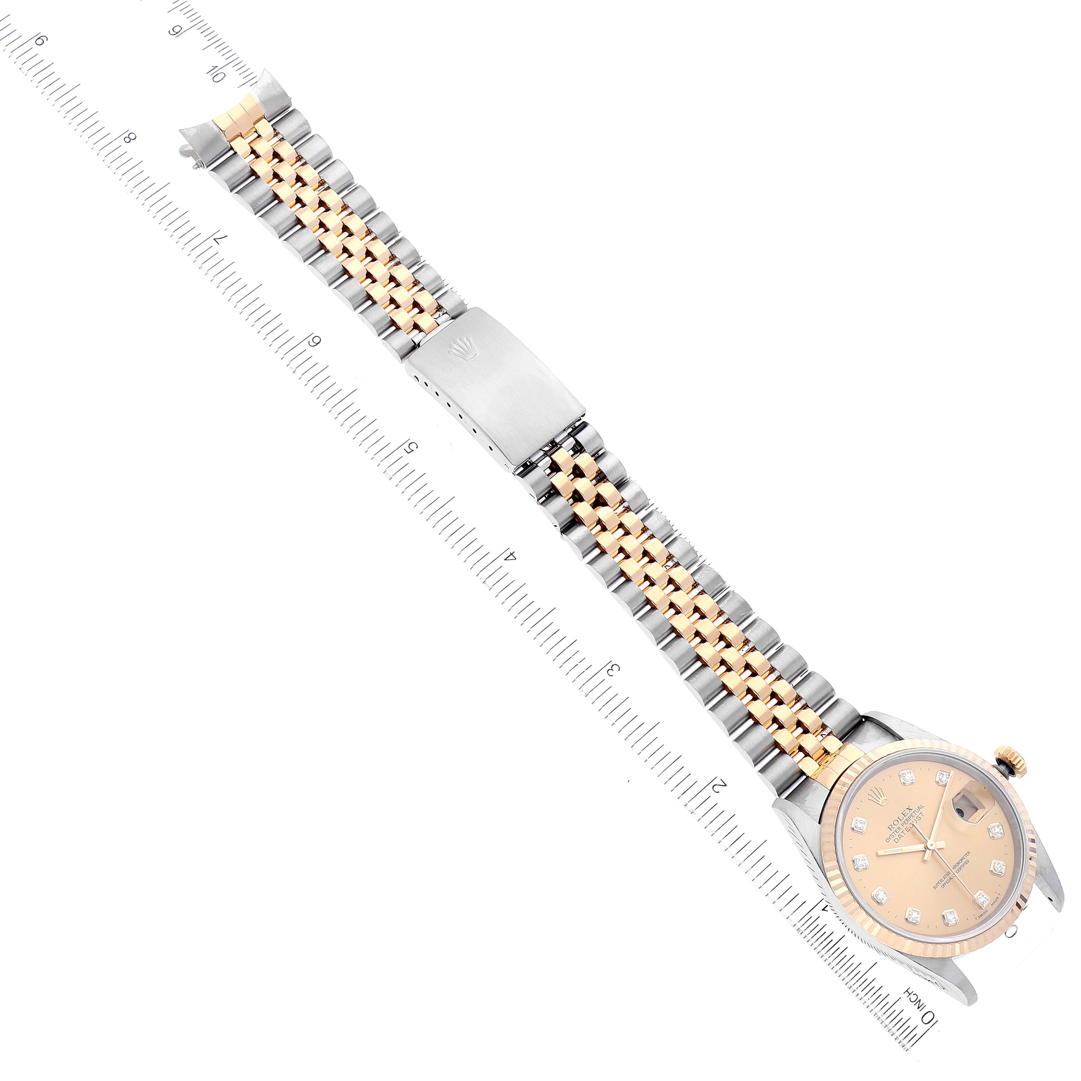 The Rolex Datejust 16233 Men's Steel and Gold (two tone) Champagne Dial 16233 Men's Steel and Gold (two tone) Champagne Dial watch is shown at an oblique angle, highlighting its face, bracelet, and clasp near a ruler.