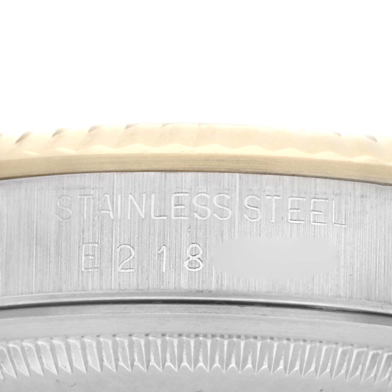The image shows a close-up view of the side of a Rolex Datejust 16233 Men
s Steel and Gold (two tone) Champagne Dial watch, focusing on the stainless steel part with engraved text.