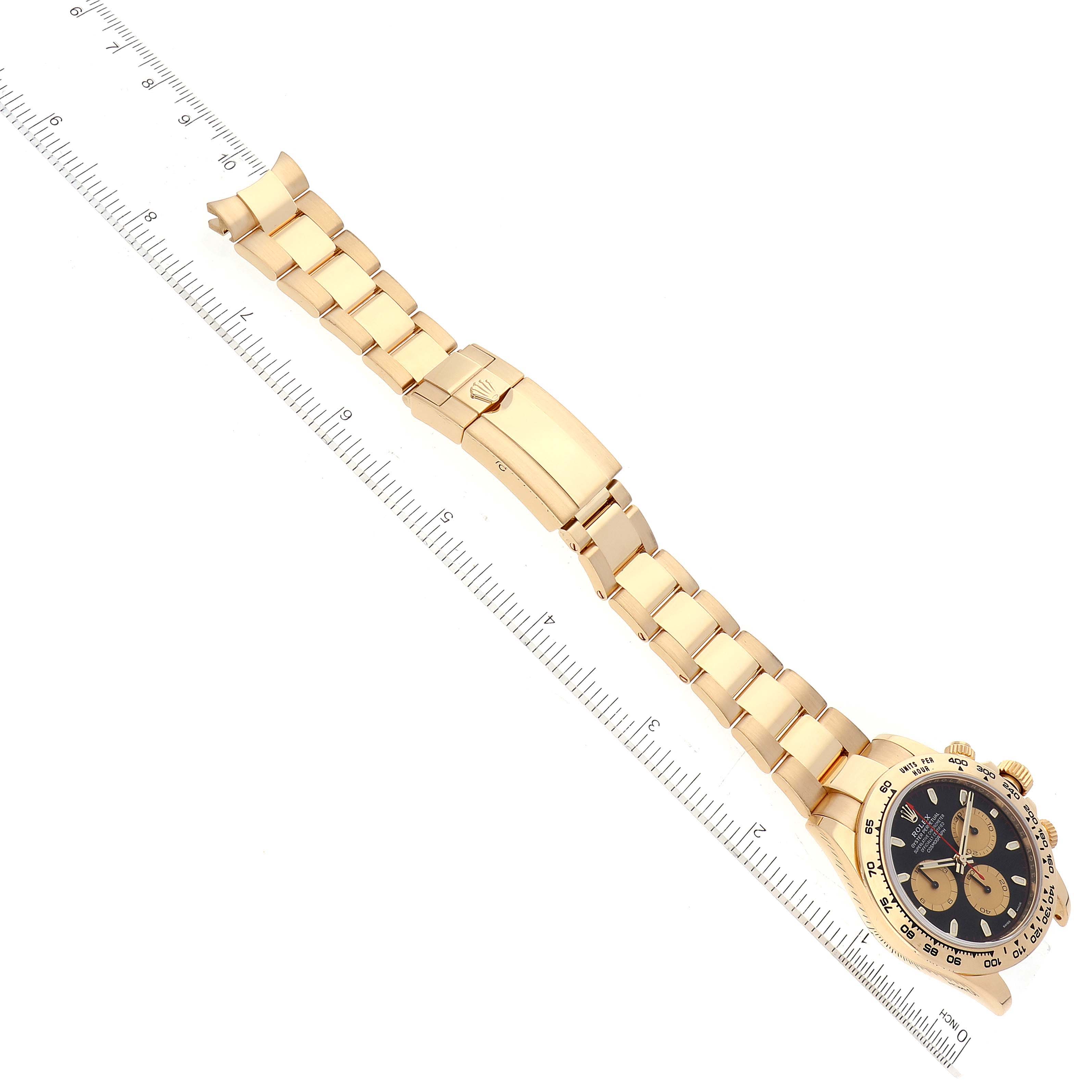 The image shows a Rolex Daytona 116508 Men's Yellow Gold Black Dial 116508 Men's Yellow Gold Black Dial watch from an overhead angle, displaying the band, clasp, and face with a ruler for scale.