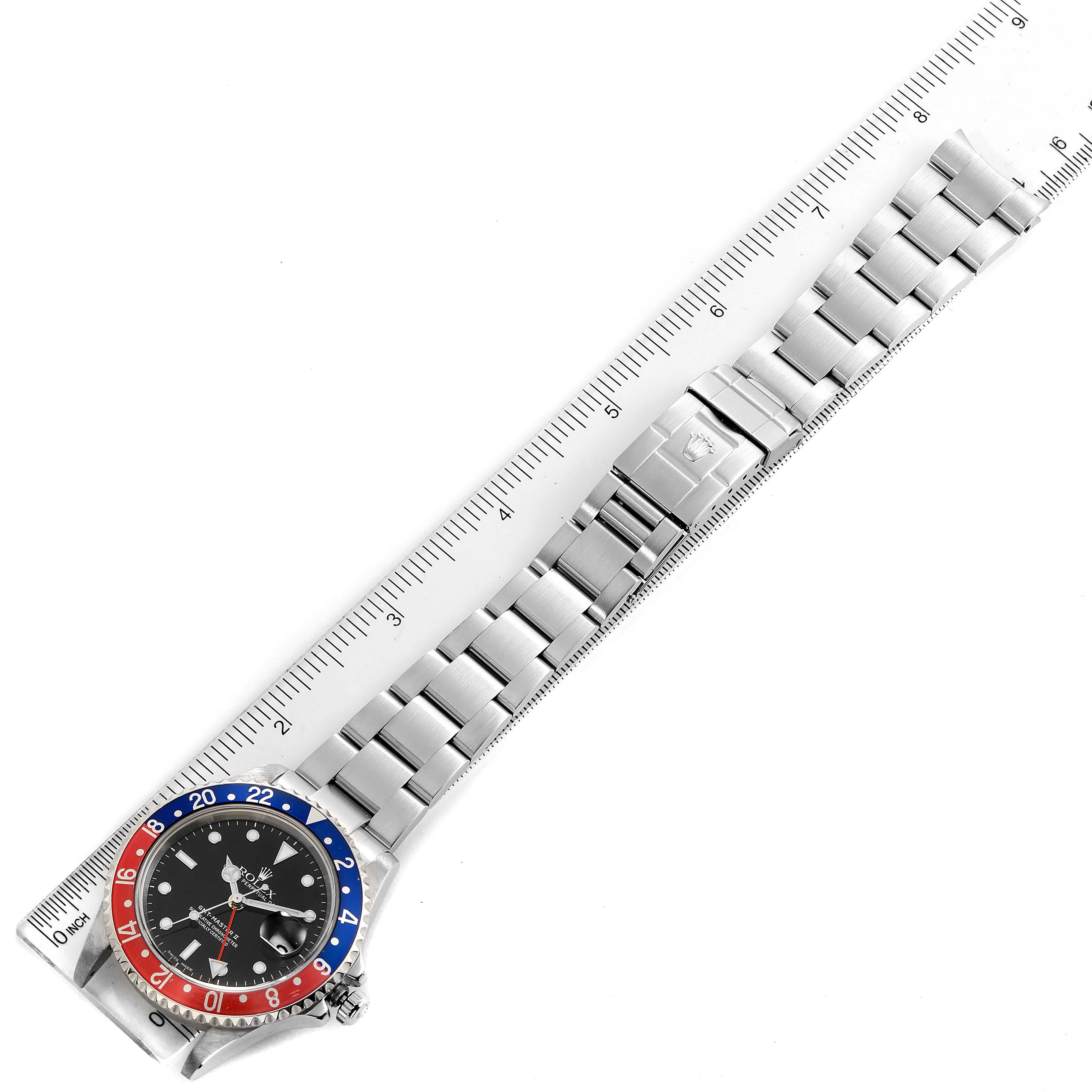 This image shows a flat view of a Rolex GMT-Master 16710 Men's Stainless Steel Black Dial 16710 Men's Stainless Steel Black Dial watch with its stainless steel bracelet and Pepsi bezel, aligned next to a ruler.