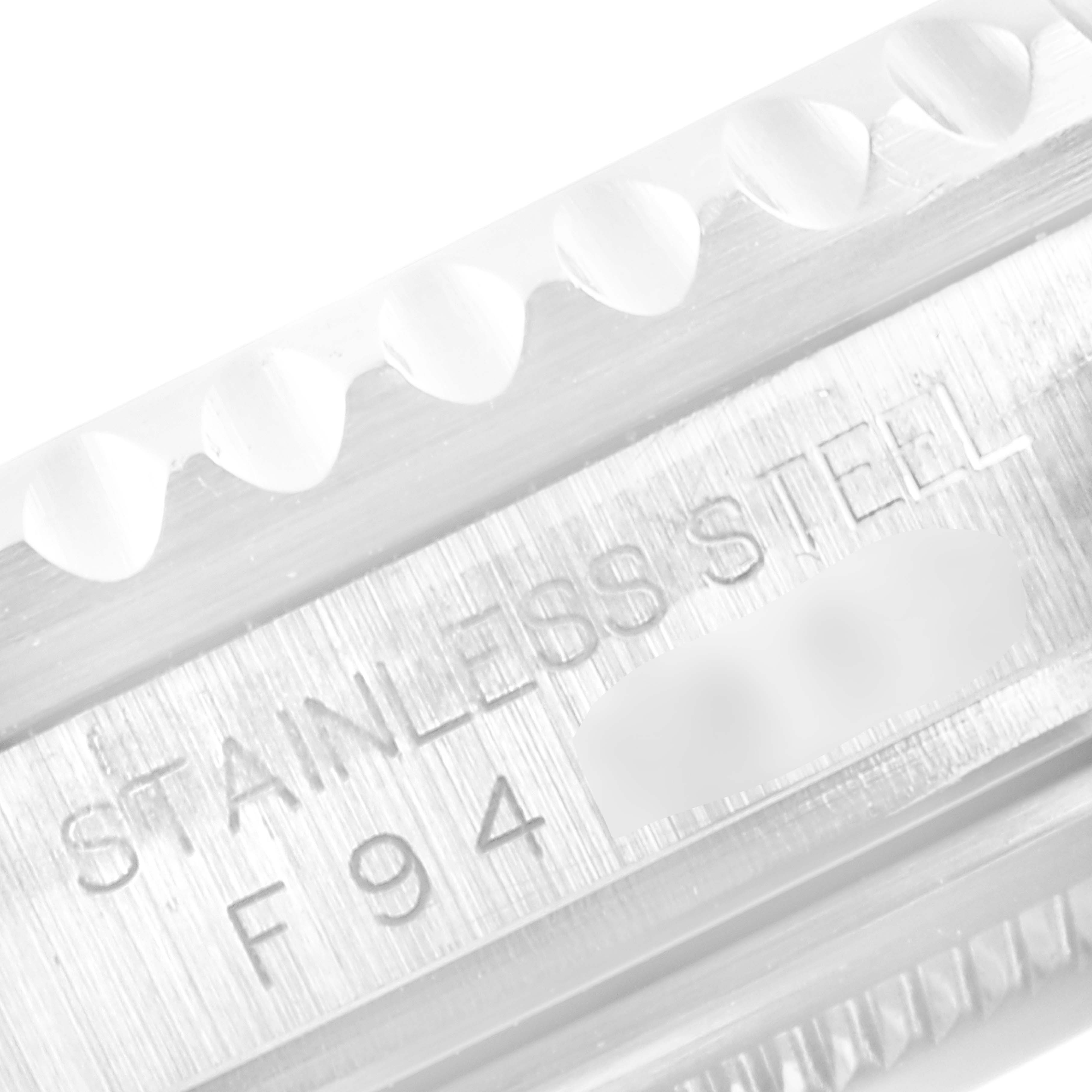 This close-up image of the Rolex GMT-Master 16710 Men's Stainless Steel Black Dial 16710 Men's Stainless Steel Black Dial watch shows the stainless steel casing with part of the engraved serial number.