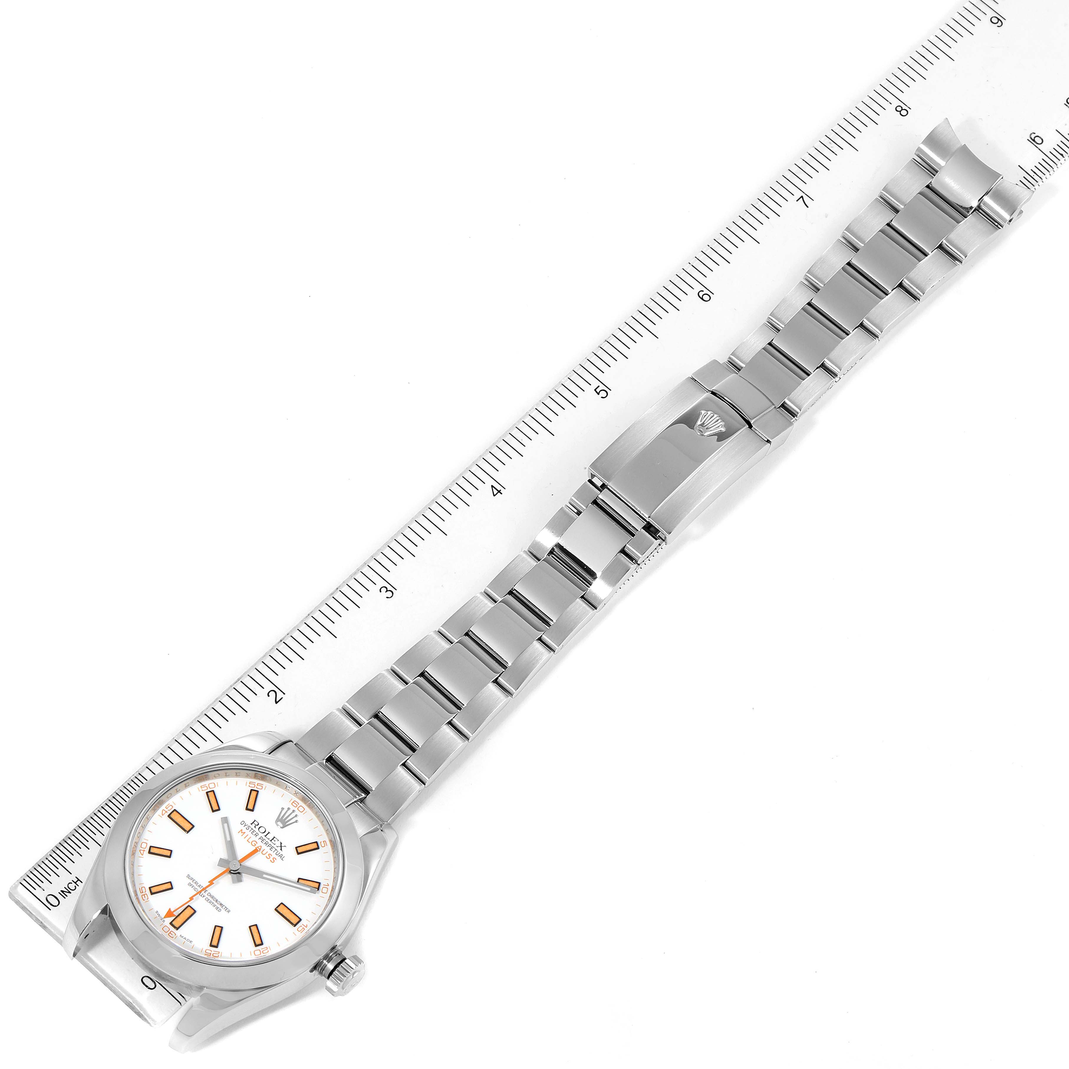 The image shows a Rolex Milgauss 116400 Men's Stainless Steel White Dial 116400 Men's Stainless Steel White Dial watch laid flat next to a ruler, highlighting the watch face, bracelet, and clasp.