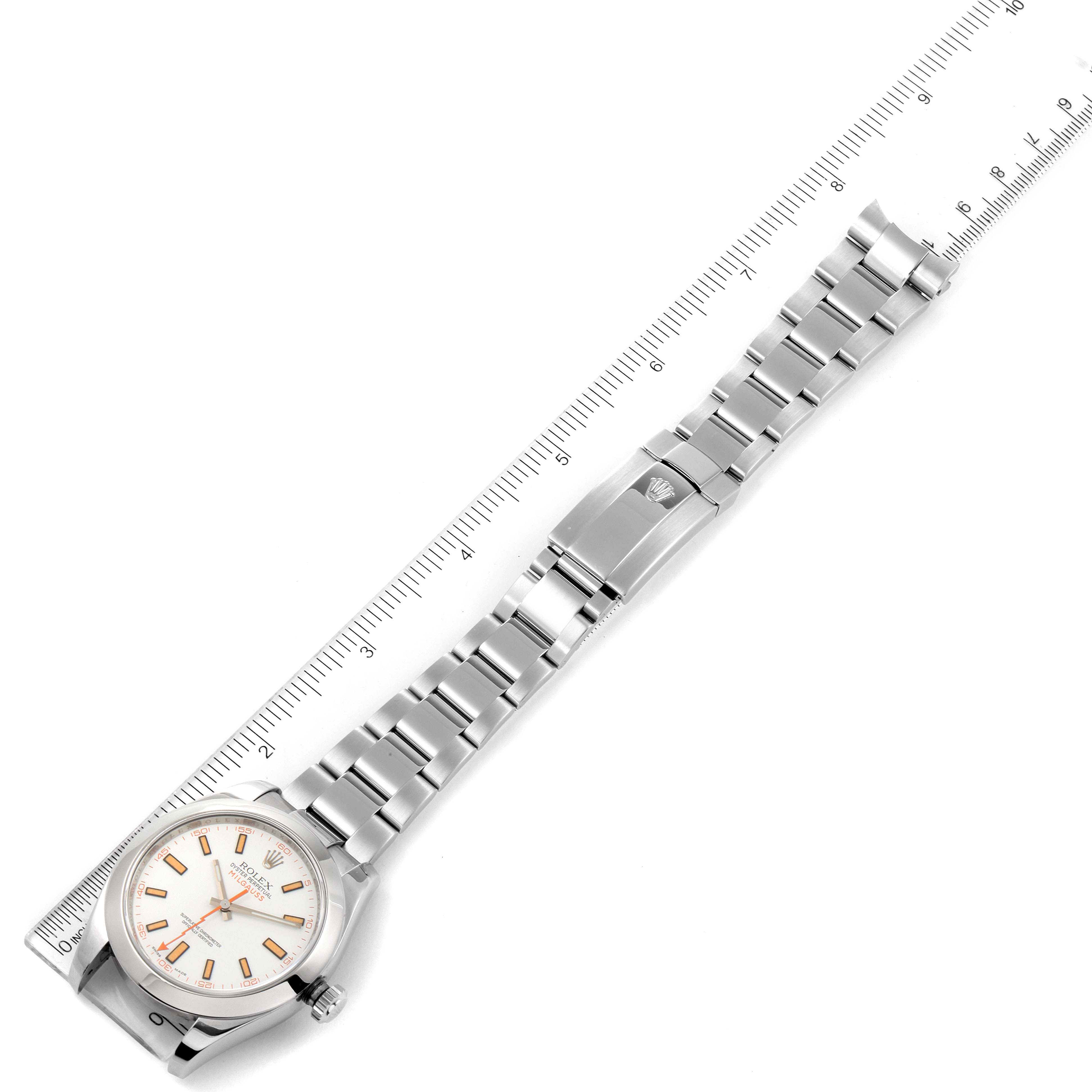 The image shows a Rolex Milgauss 116400 Men's Stainless Steel White Dial 116400 Men's Stainless Steel White Dial watch laid flat with a ruler next to it, displaying the face, bracelet, and clasp.