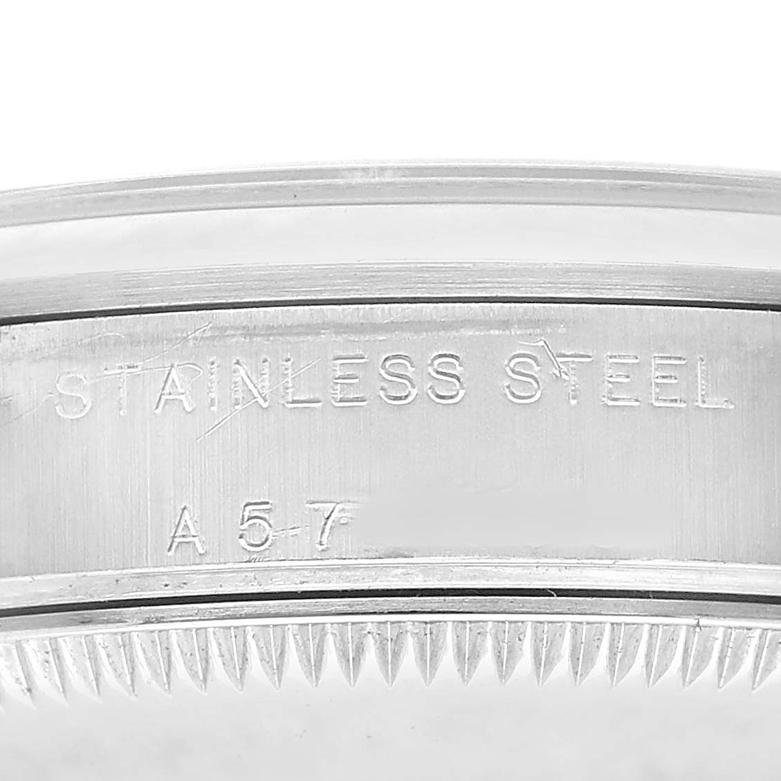 The image shows a close-up of the engraving on the stainless steel case of a Rolex Oyster Perpetual 77080 Women's Stainless Steel White Dial watch.