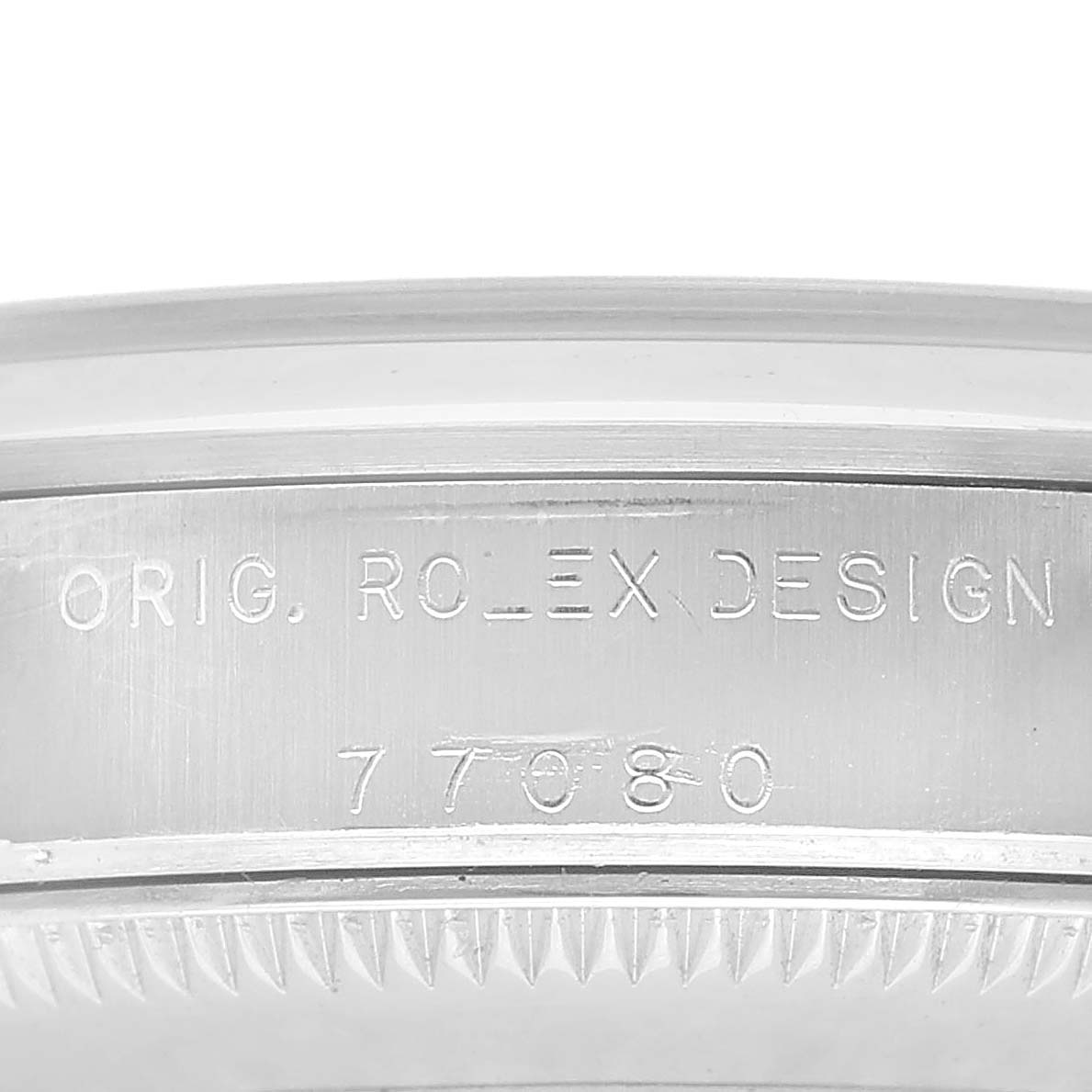The image shows a close-up of the engraved side of a Rolex Oyster Perpetual 77080 Women's Stainless Steel White Dial watch case with model number details.