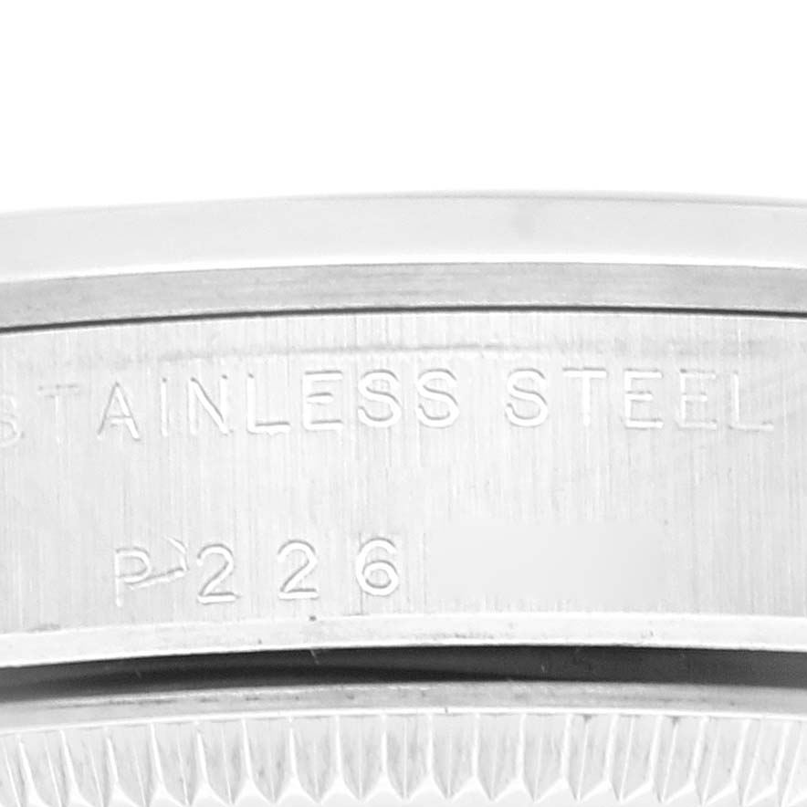 The image shows a close-up of the case back engraving of a Rolex Mid-Size 77080 Women
s Stainless Steel White Dial 77080 Women
s Stainless Steel White Dial model, highlighting the "STAINLESS STEEL" inscription.