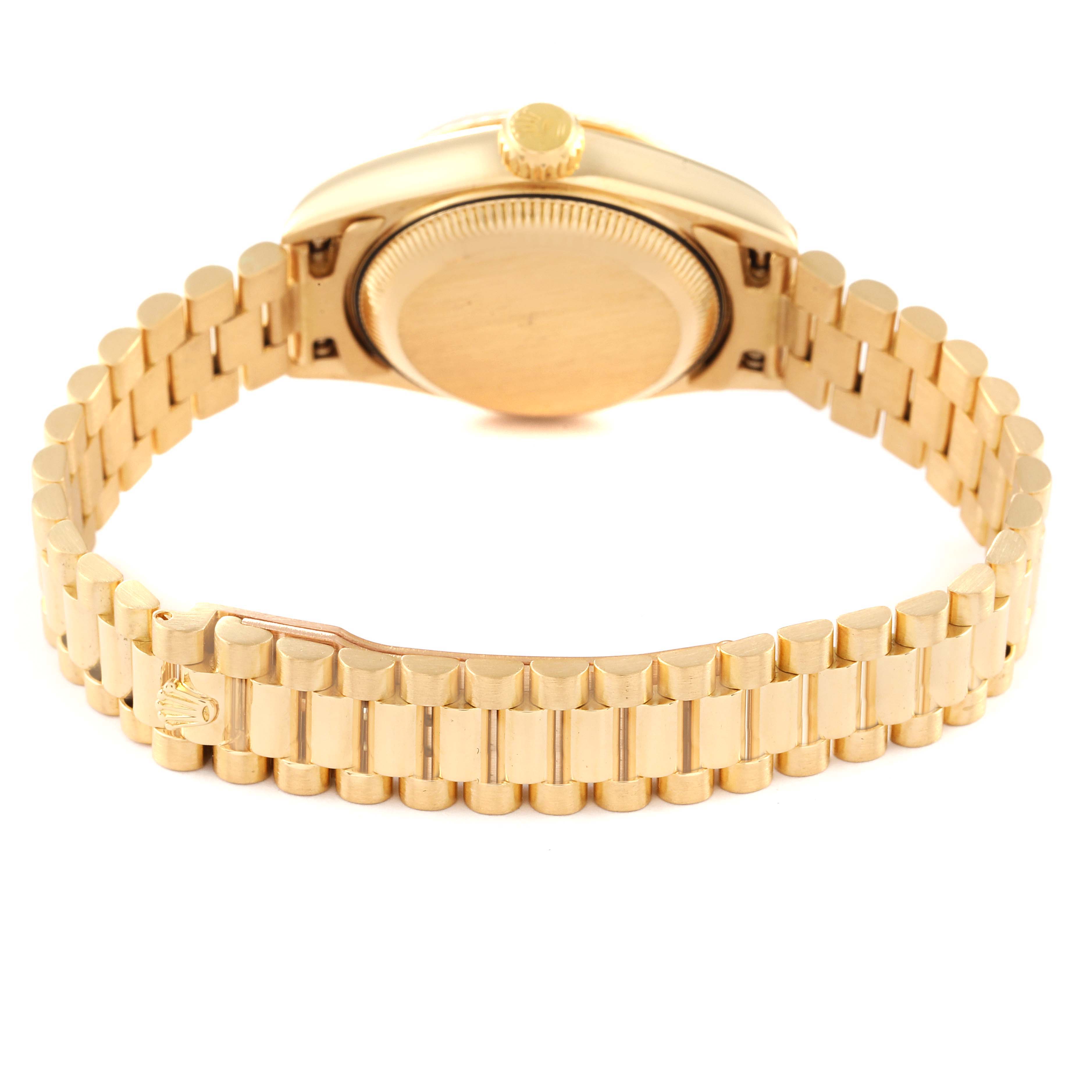 The image shows the back of a Rolex President 69178 Women's Yellow Gold Champagne Dial 69178 Women's Yellow Gold Champagne Dial model watch and its gold link bracelet.