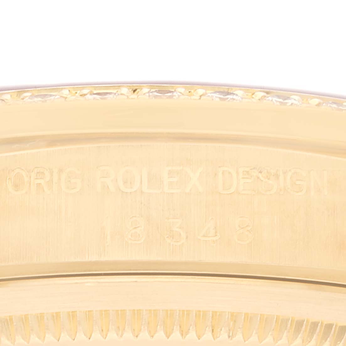 This close-up image shows the side view of the bezel and case of a Rolex President 18348 Men's Yellow Gold Champagne Dial 18348 Men's Yellow Gold Champagne Dial model watch, highlighting its engraved details.