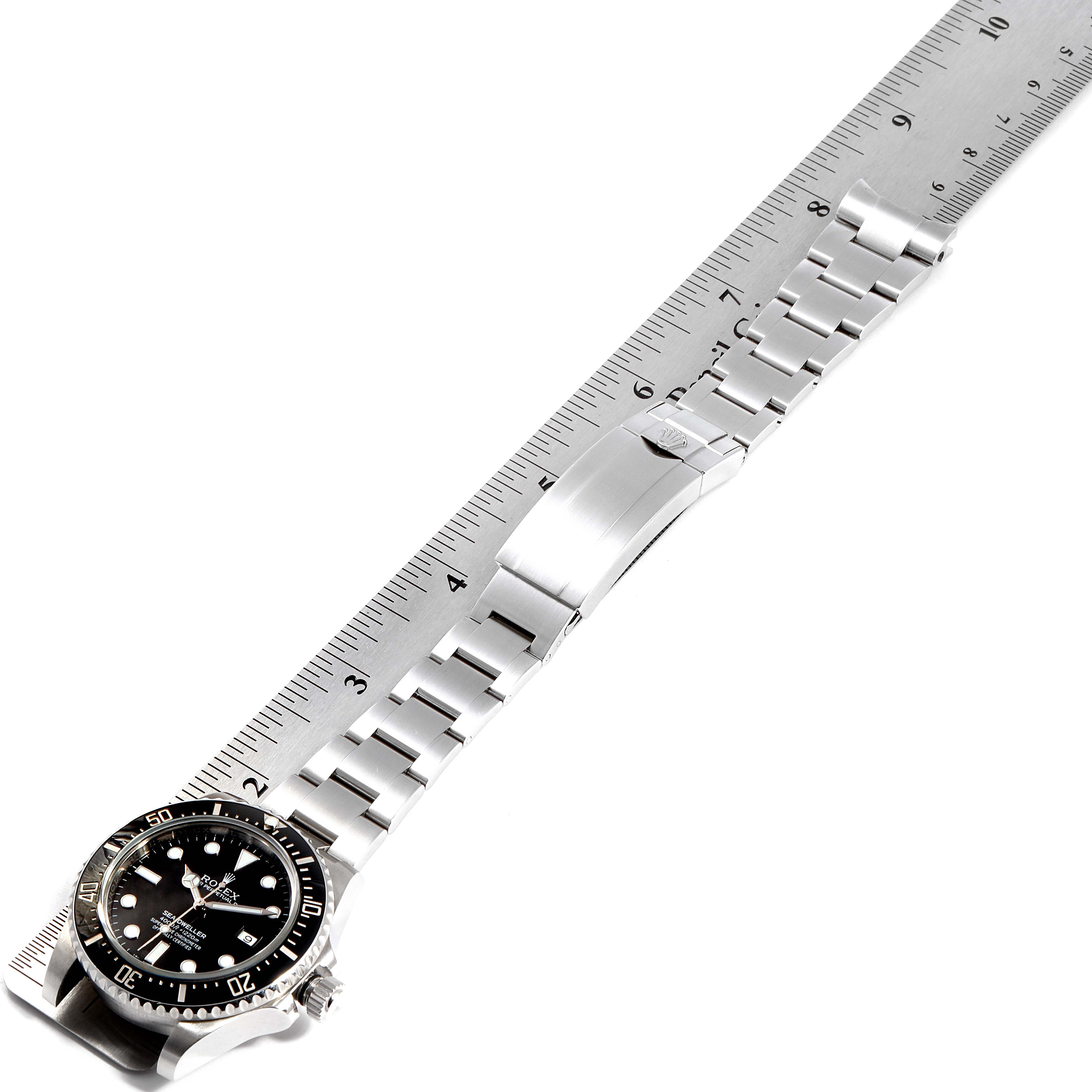 The image shows a Rolex Sea-Dweller 116600 Men
s Stainless Steel Black Dial 116600 Men
s Stainless Steel Black Dial watch laid flat with a measuring ruler, displaying the stainless steel bracelet and clasp.