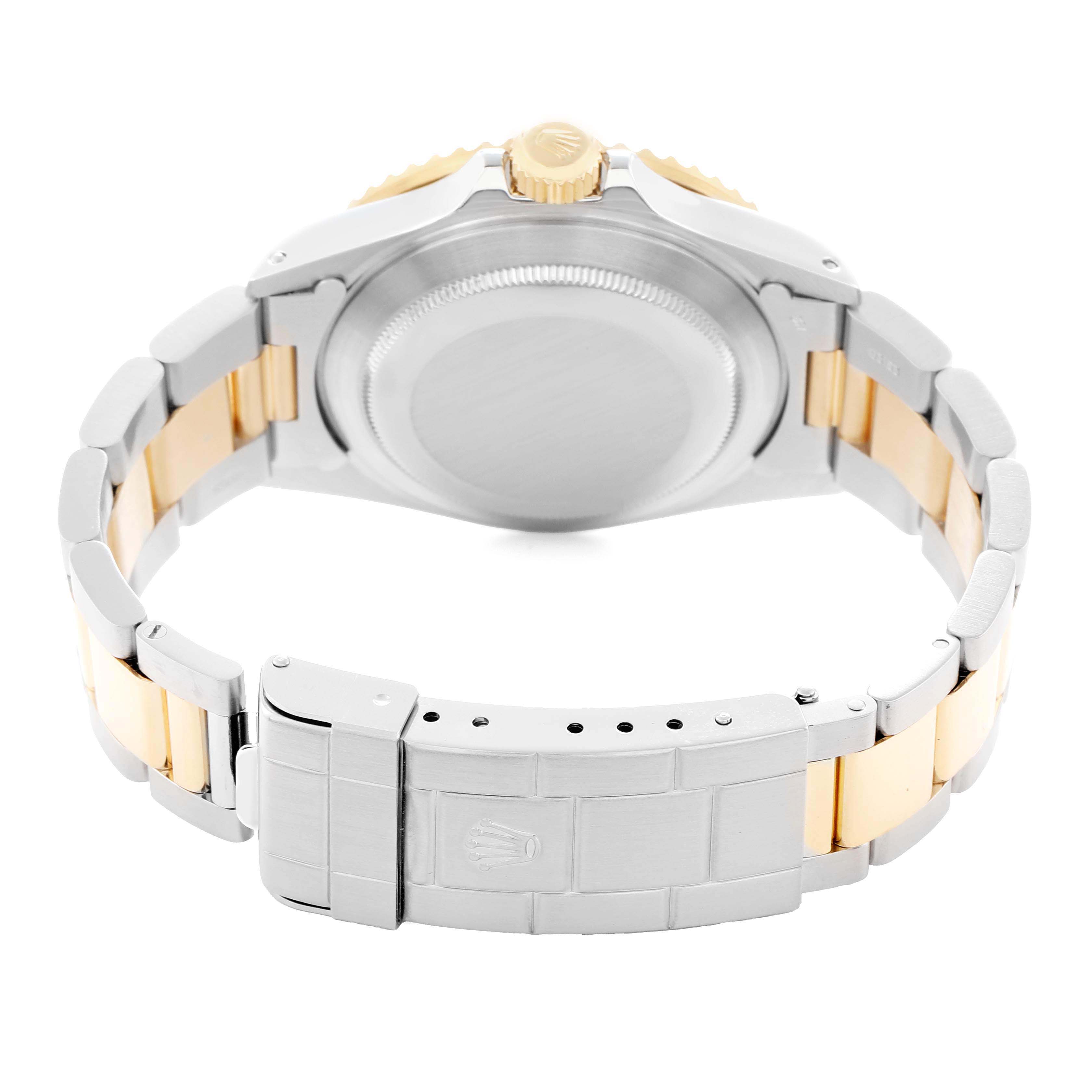 The image shows the back of a Rolex Submariner 16803 Men
s Steel and Gold (two tone) Black Dial watch, highlighting its caseback, crown, and metal bracelet with folding clasp.