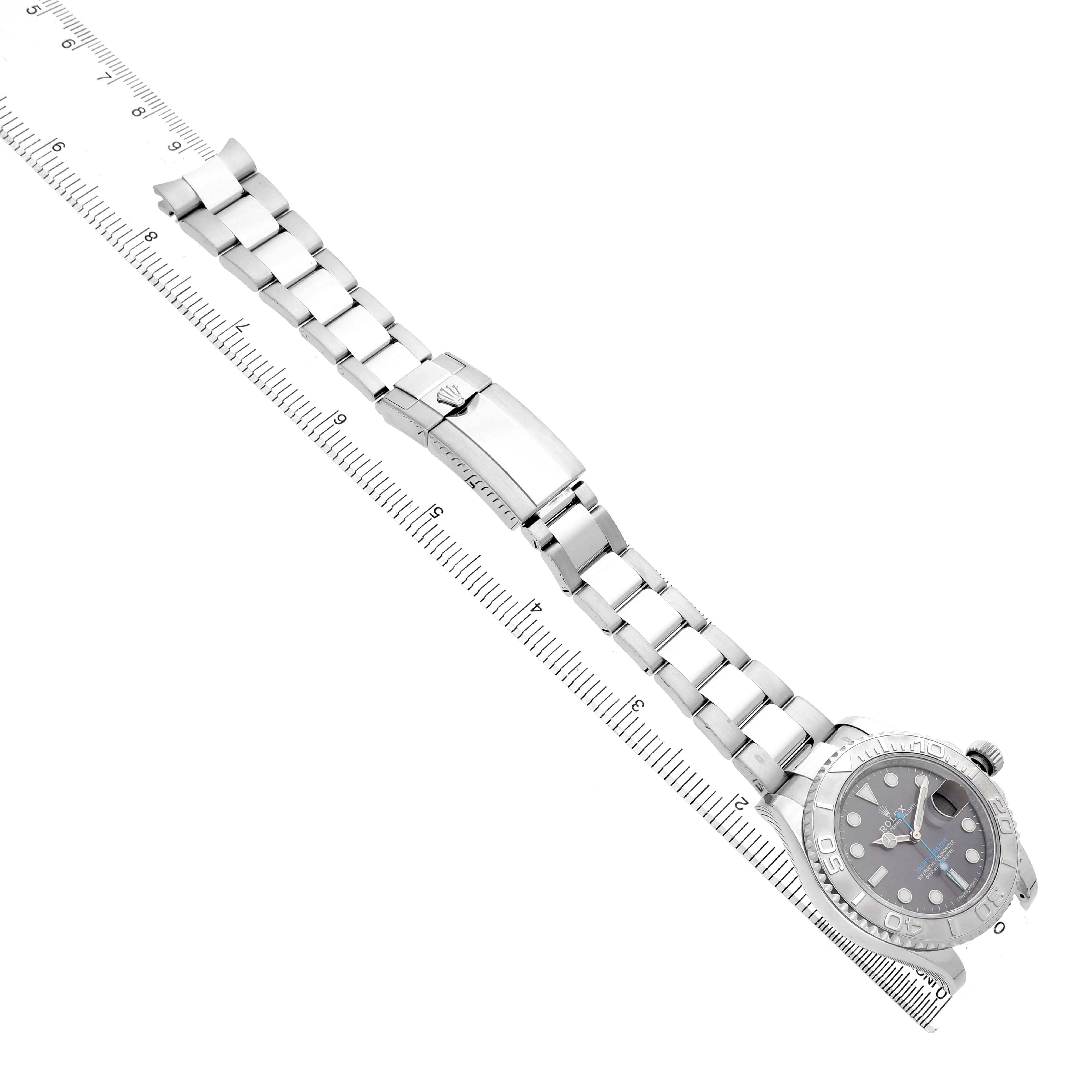 The Rolex Yacht-Master 116622 Men's Stainless Steel Grey Dial watch is shown from an angled top view, displaying the watch face, bracelet, and clasp beside a ruler for scale.