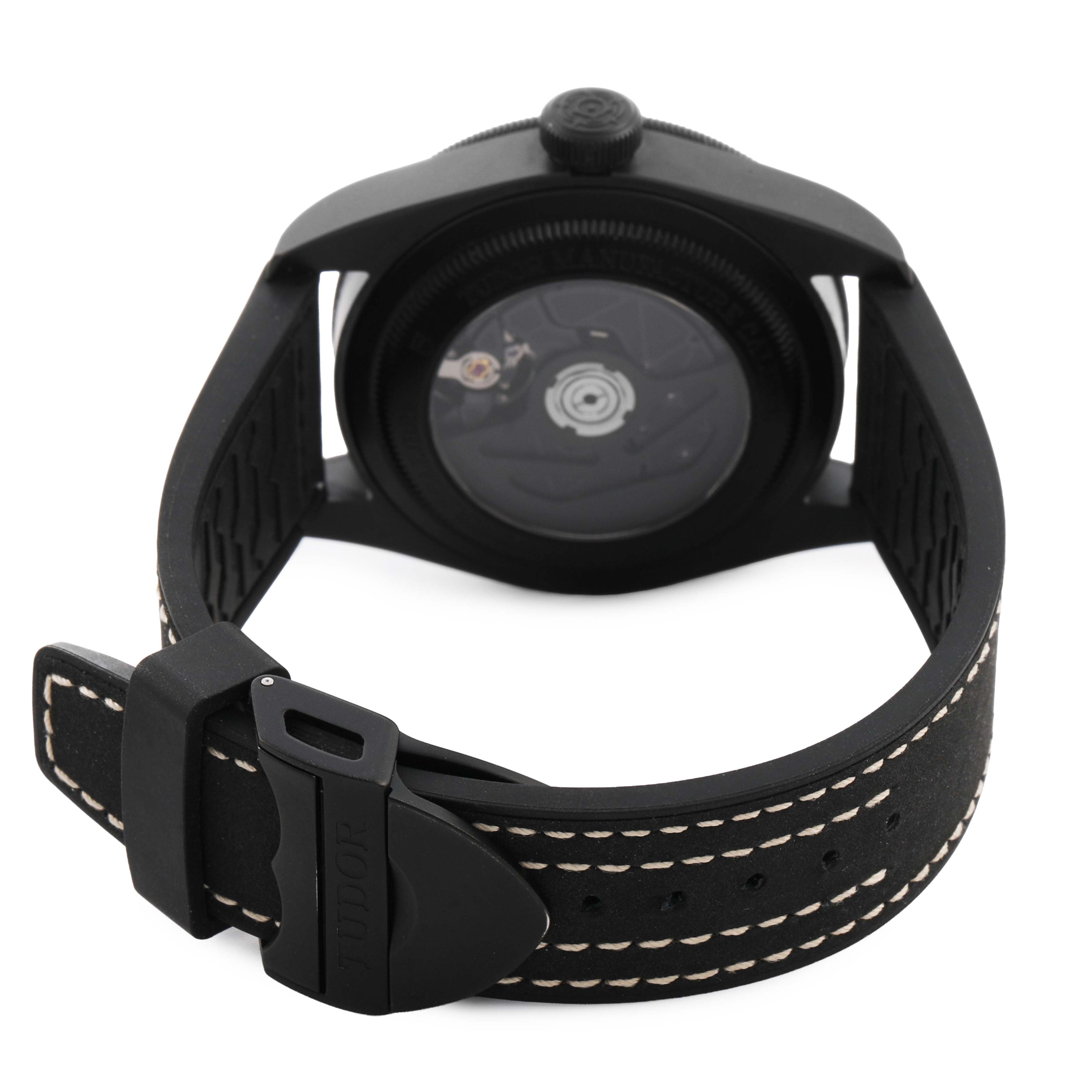 The Tudor Heritage Black Bay M79210CNU Men's Ceramic Black Dial watch is shown from the back, displaying the case and strap with visible stitching.