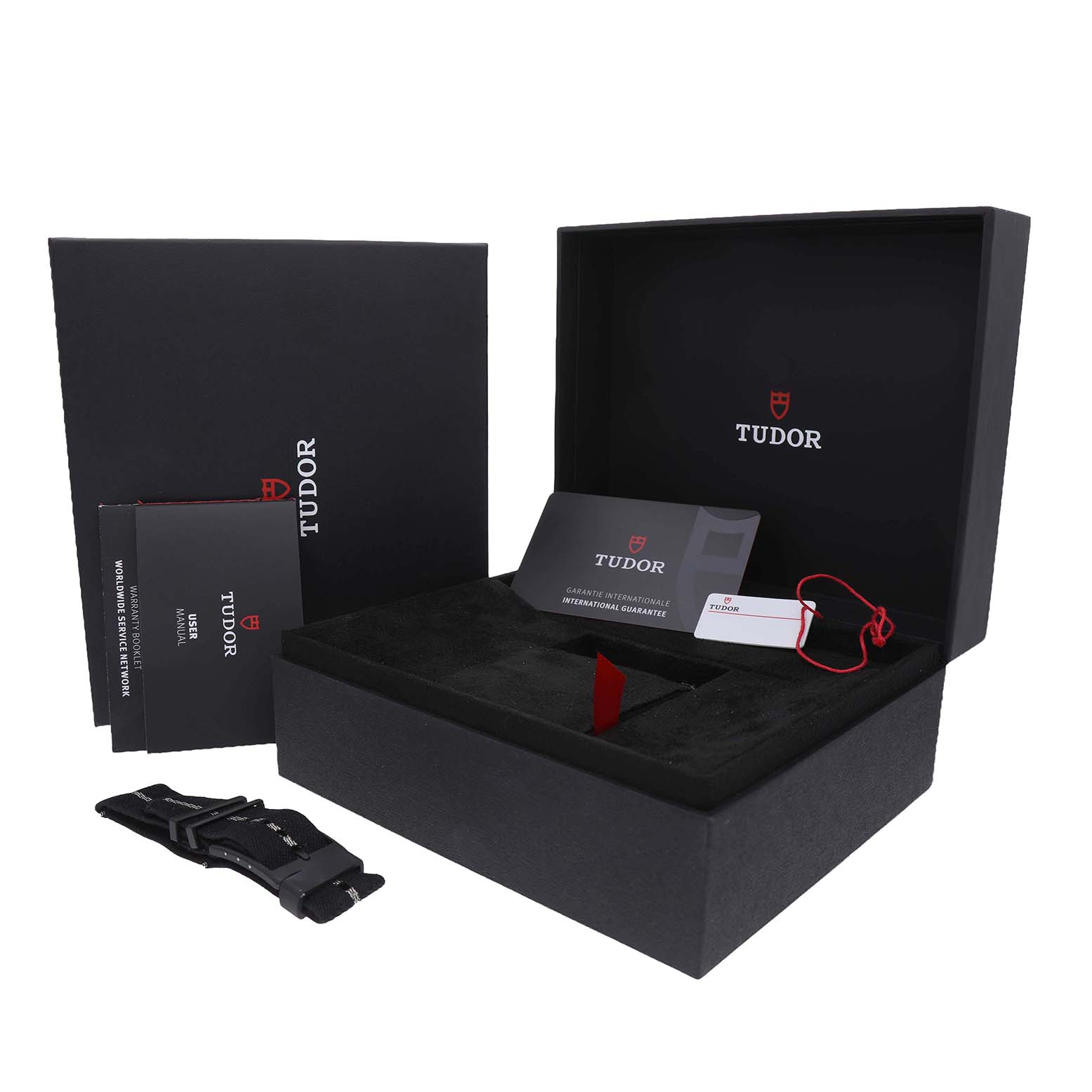The image shows the Tudor Heritage Black Bay M79210CNU Men's Ceramic Black Dial packaging with box, manuals, card, and an additional strap.